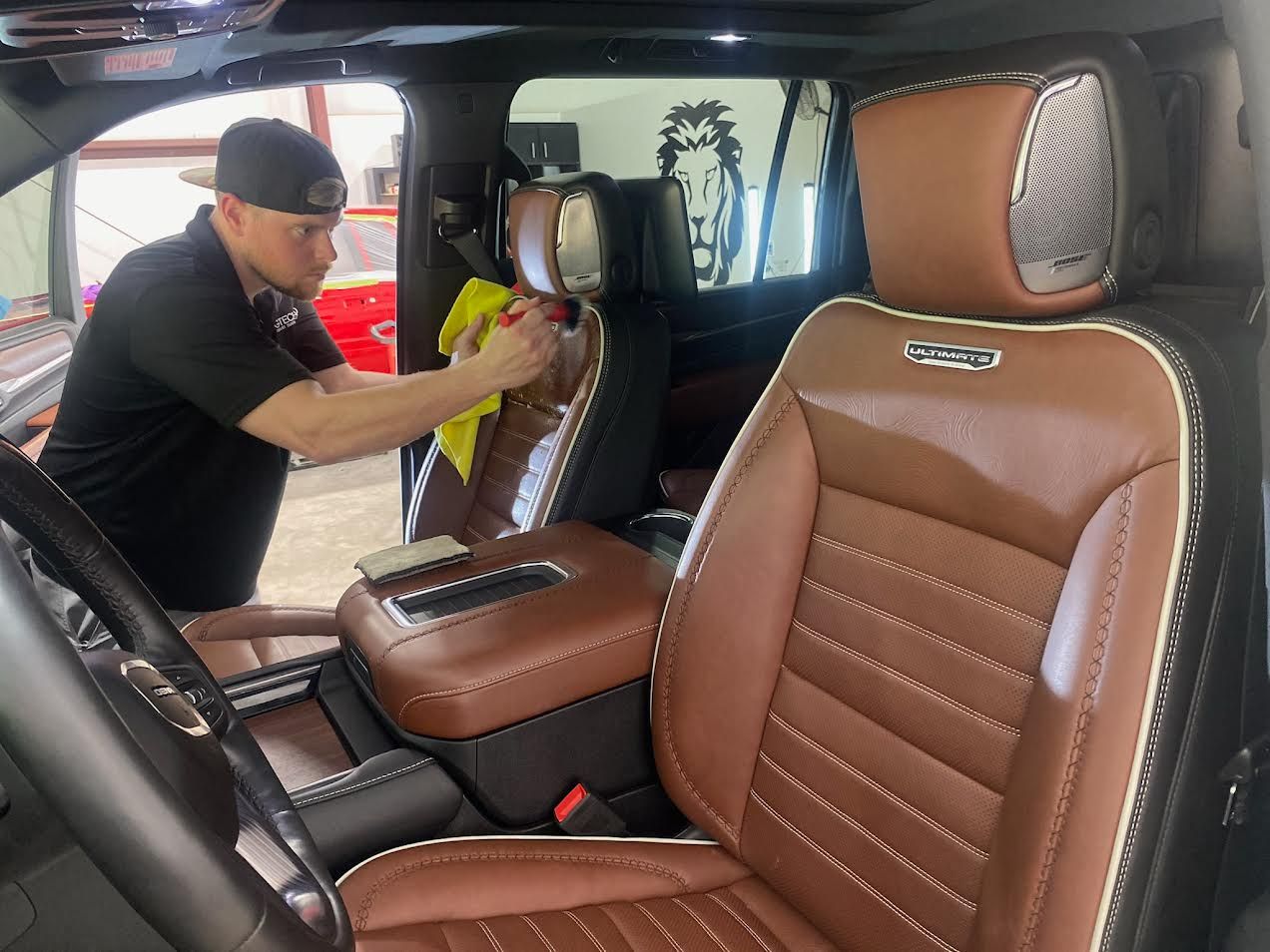 A man is cleaning the seats of a car with a cloth.