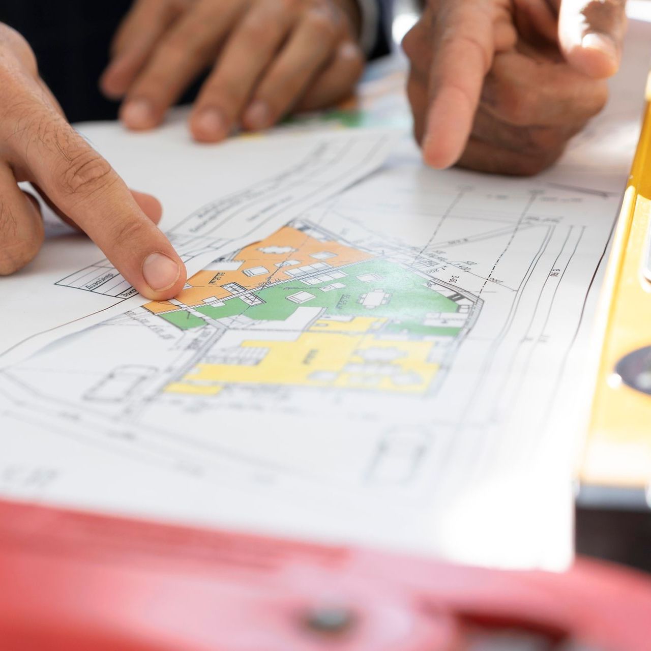 Žmogus rodo į namo brėžinį