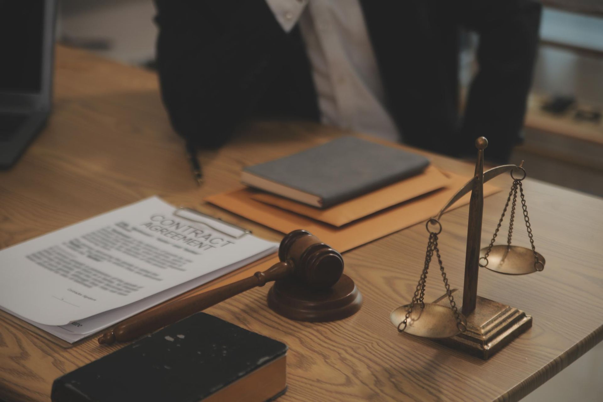 Lawyer's desk with contract, books, gavel, and scales of justice.