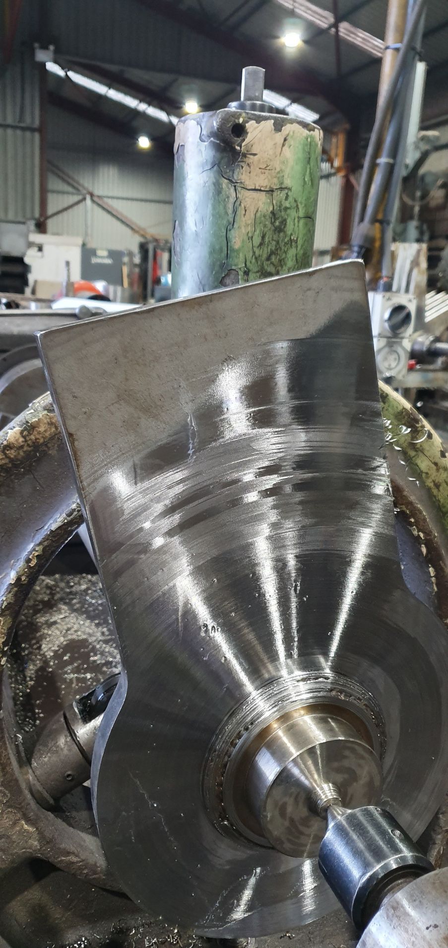 A piece of metal is sitting on top of a machine in a factory.