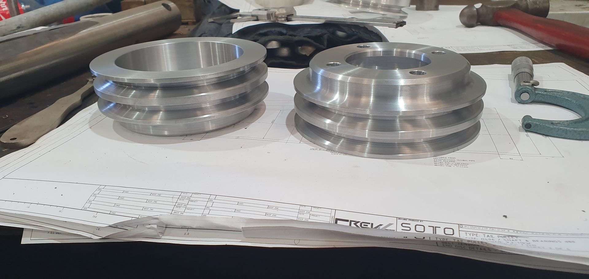 Two metal pulleys are sitting on top of a piece of paper.