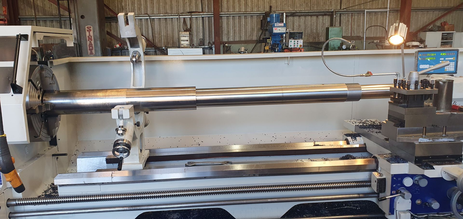 A large lathe is sitting in a factory.