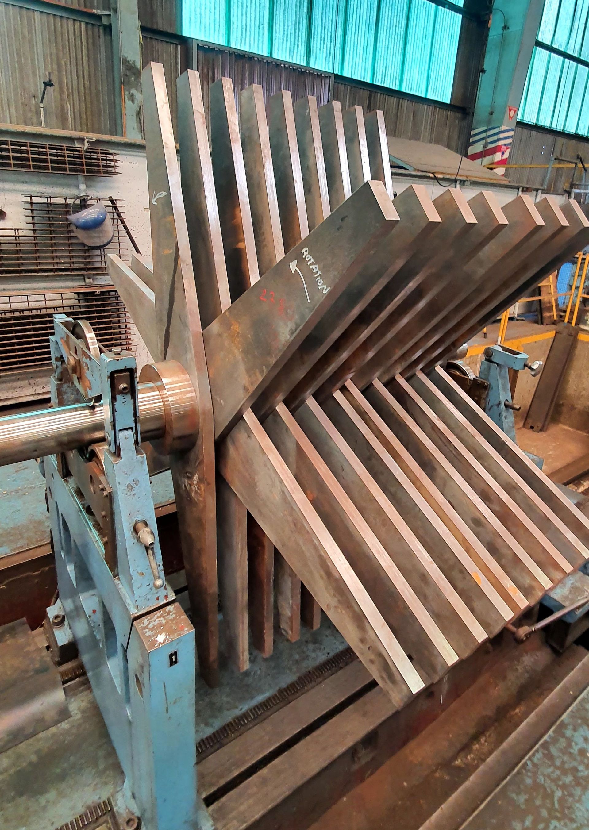 A large piece of metal is sitting on top of a machine in a factory.