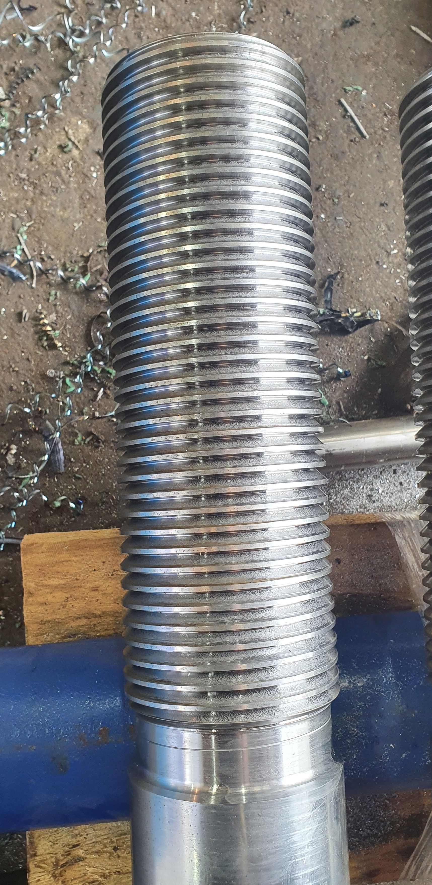 A close up of a metal bolt sitting on top of a wooden table.