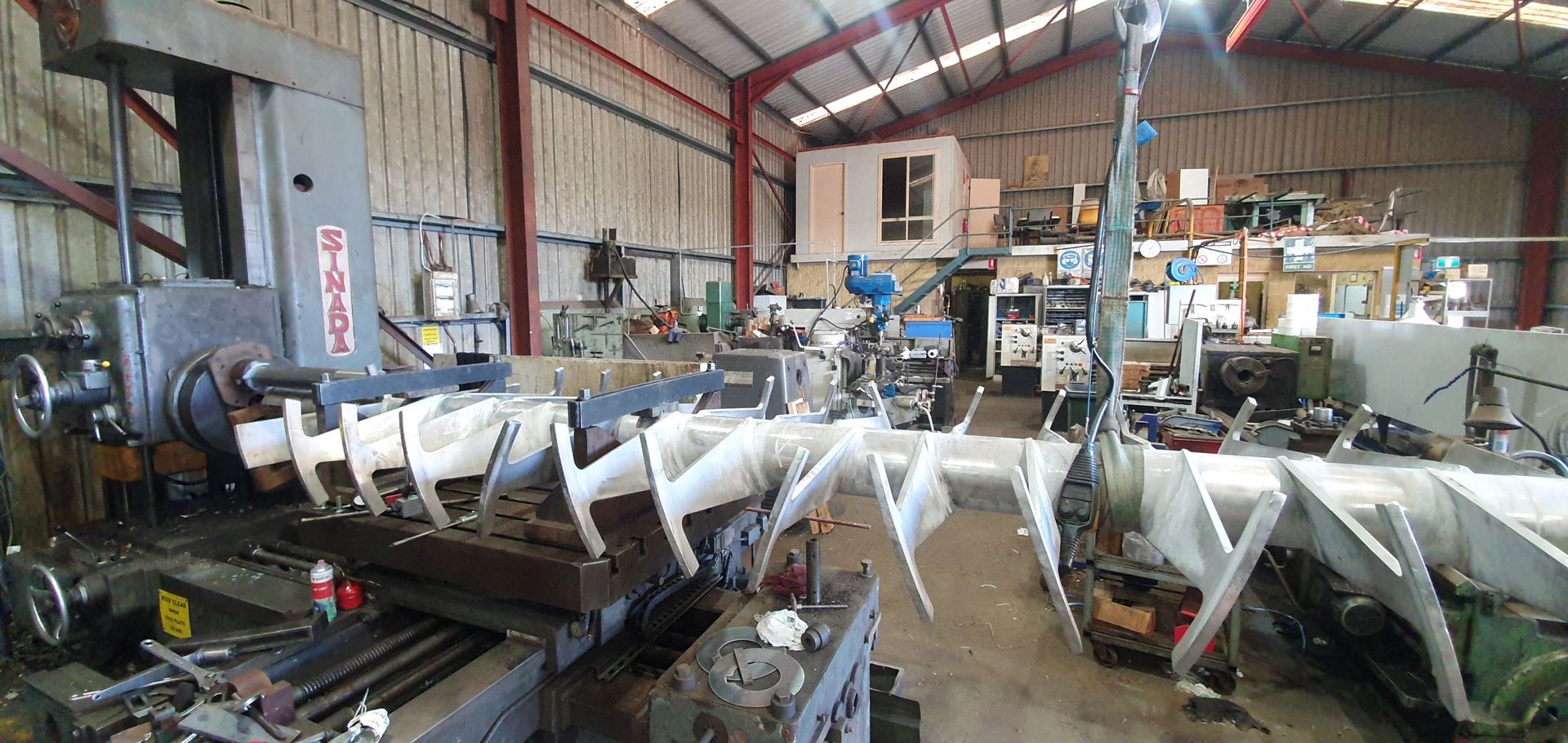 A large machine is sitting in a large warehouse.