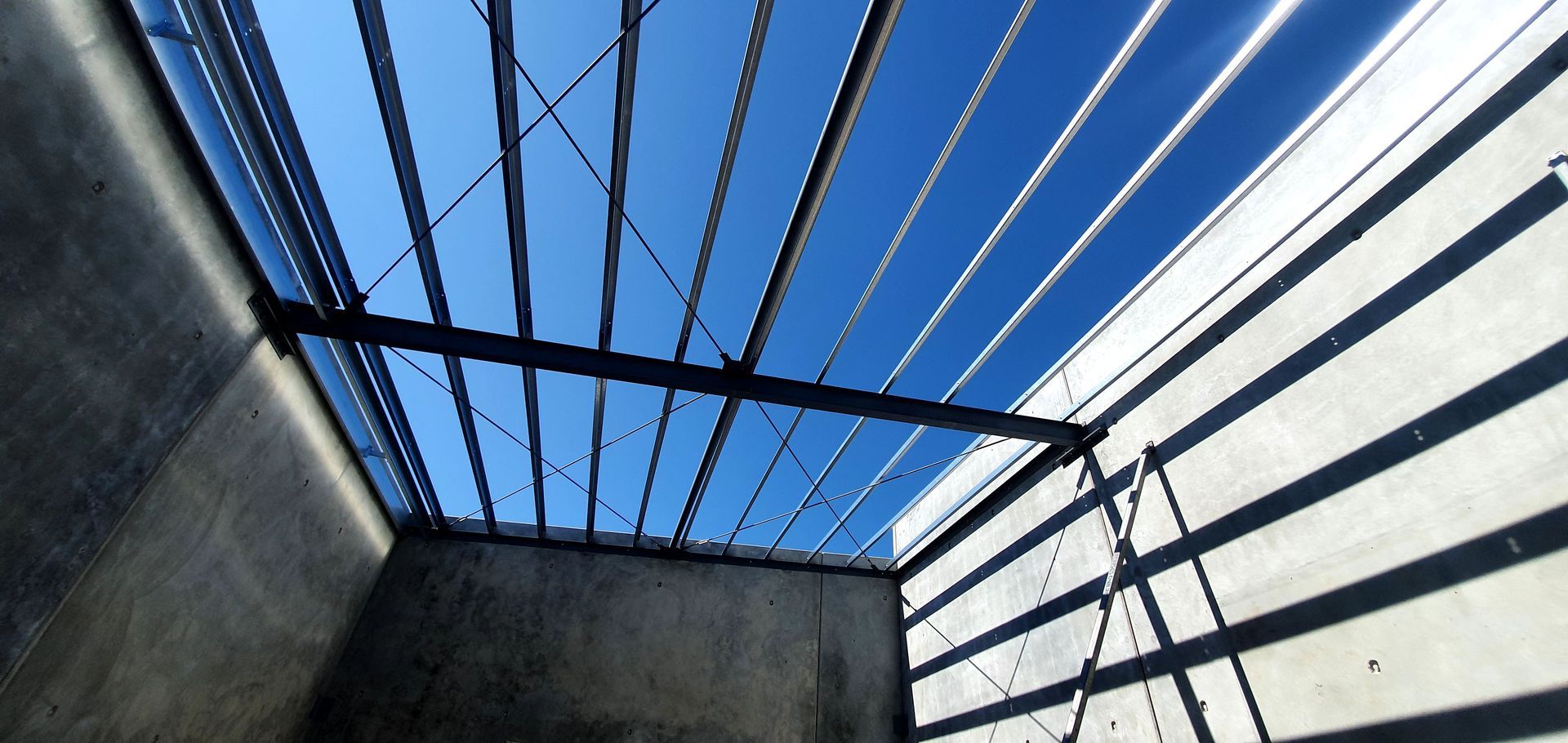 Looking up at the ceiling of a building with a blue sky in the background