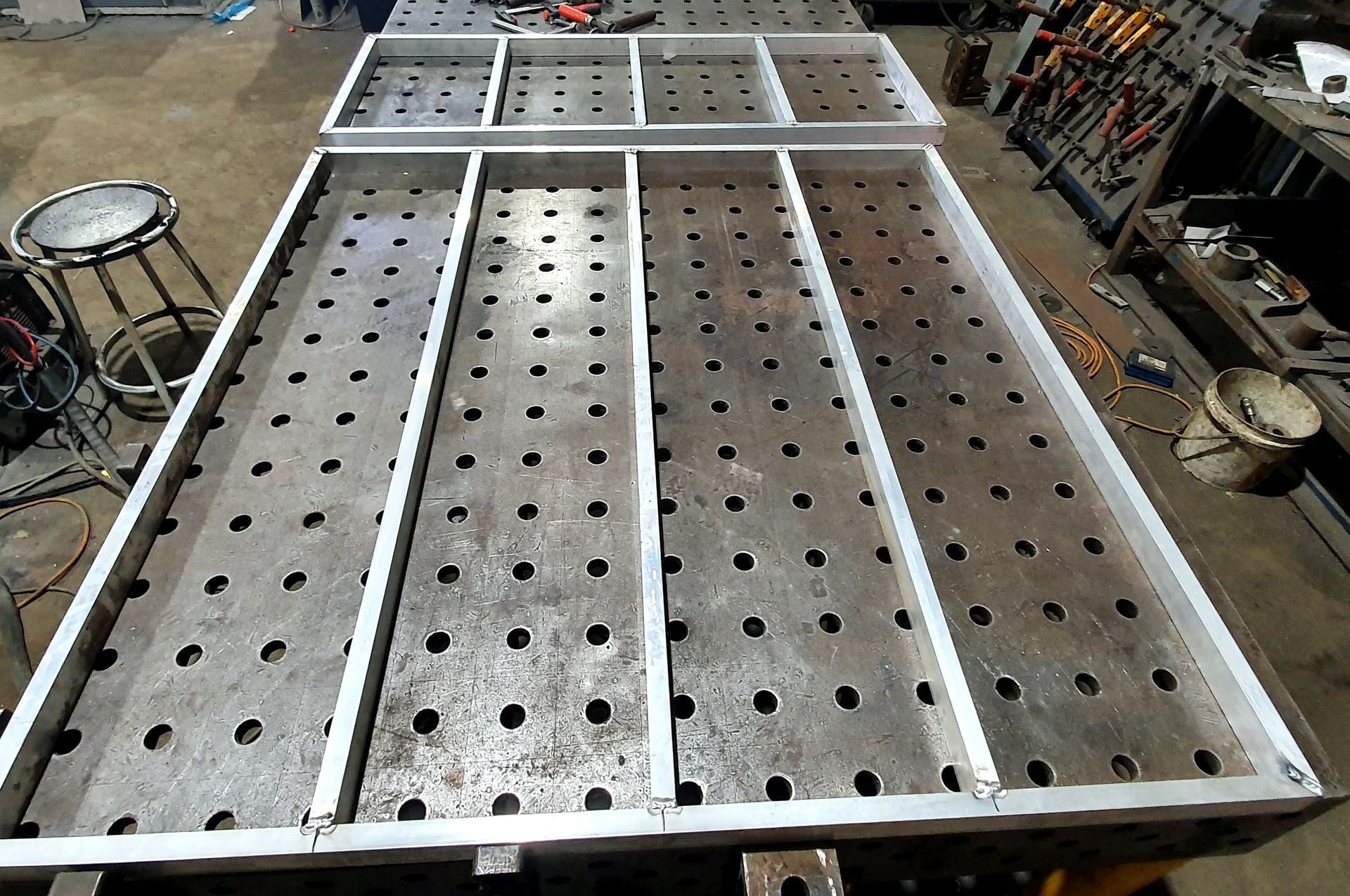 A metal table with holes in it in a workshop