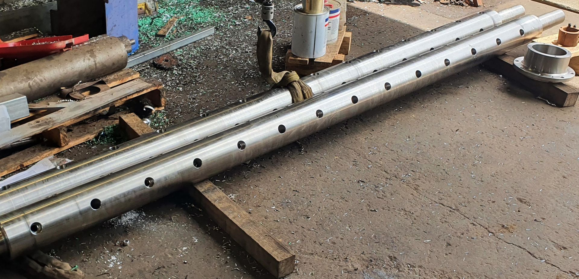A pair of metal pipes sitting on top of a wooden pallet.