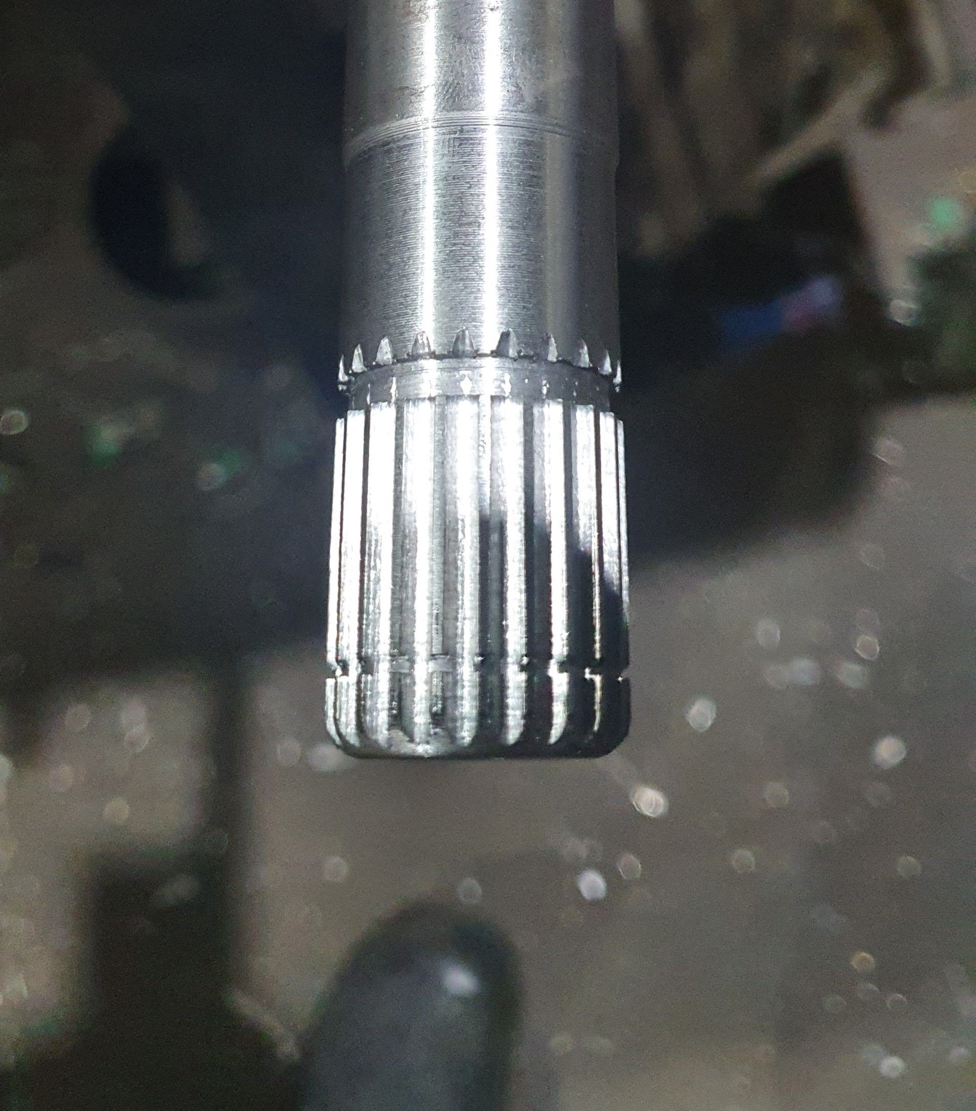 A close up of a metal shaft with a few holes in it
