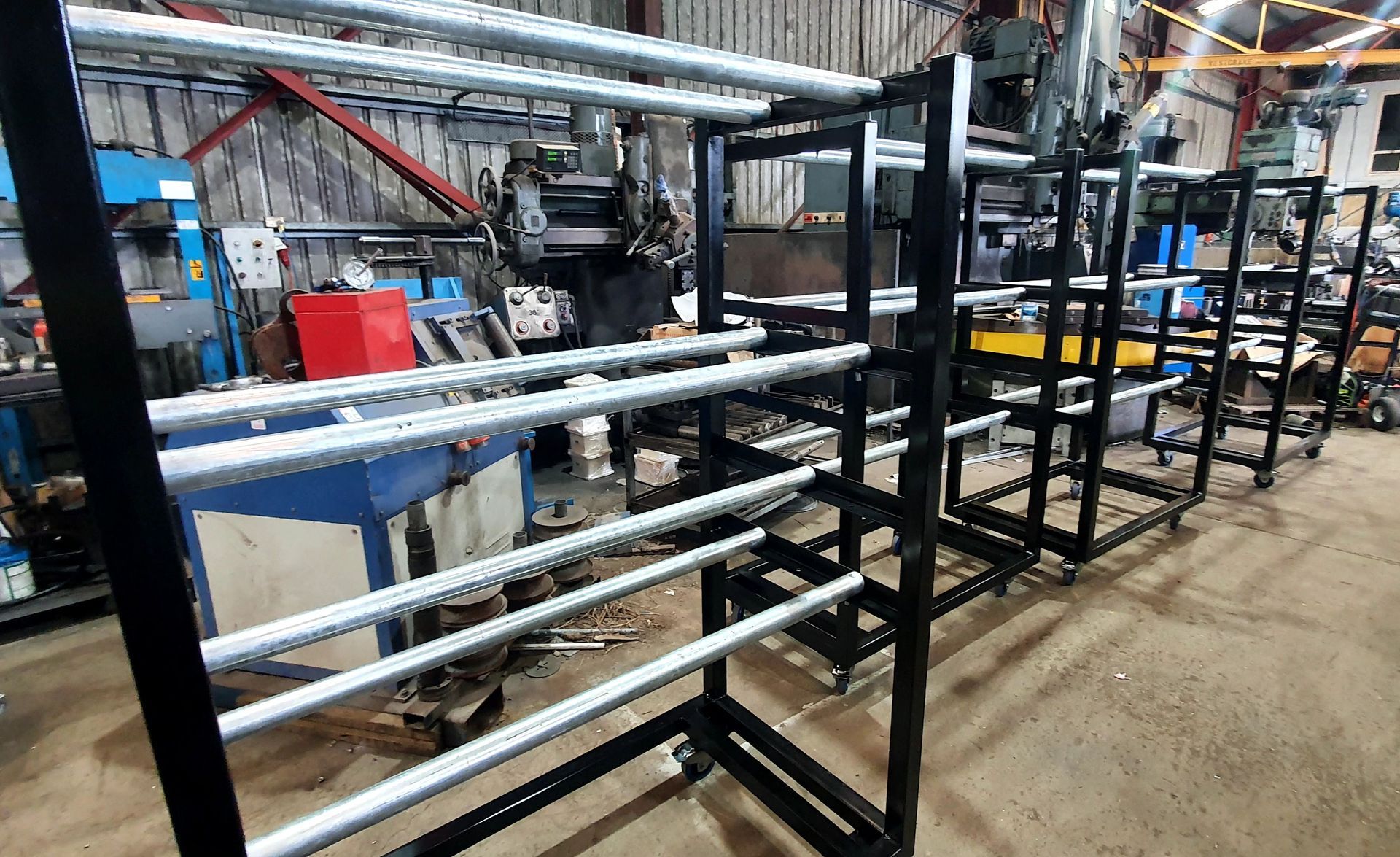 A row of metal racks are sitting in a factory.
