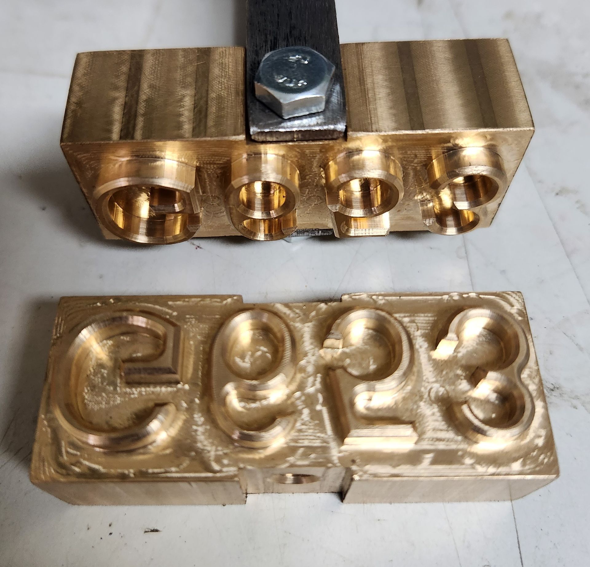 A brass block with the number 1023 on it