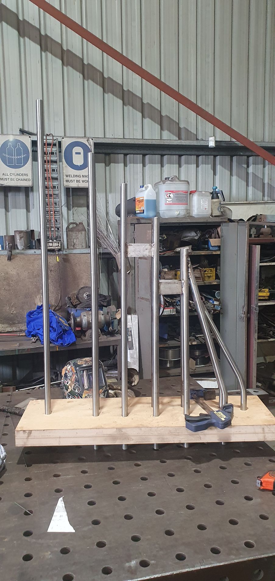 A bunch of metal poles are sitting on top of a wooden table.