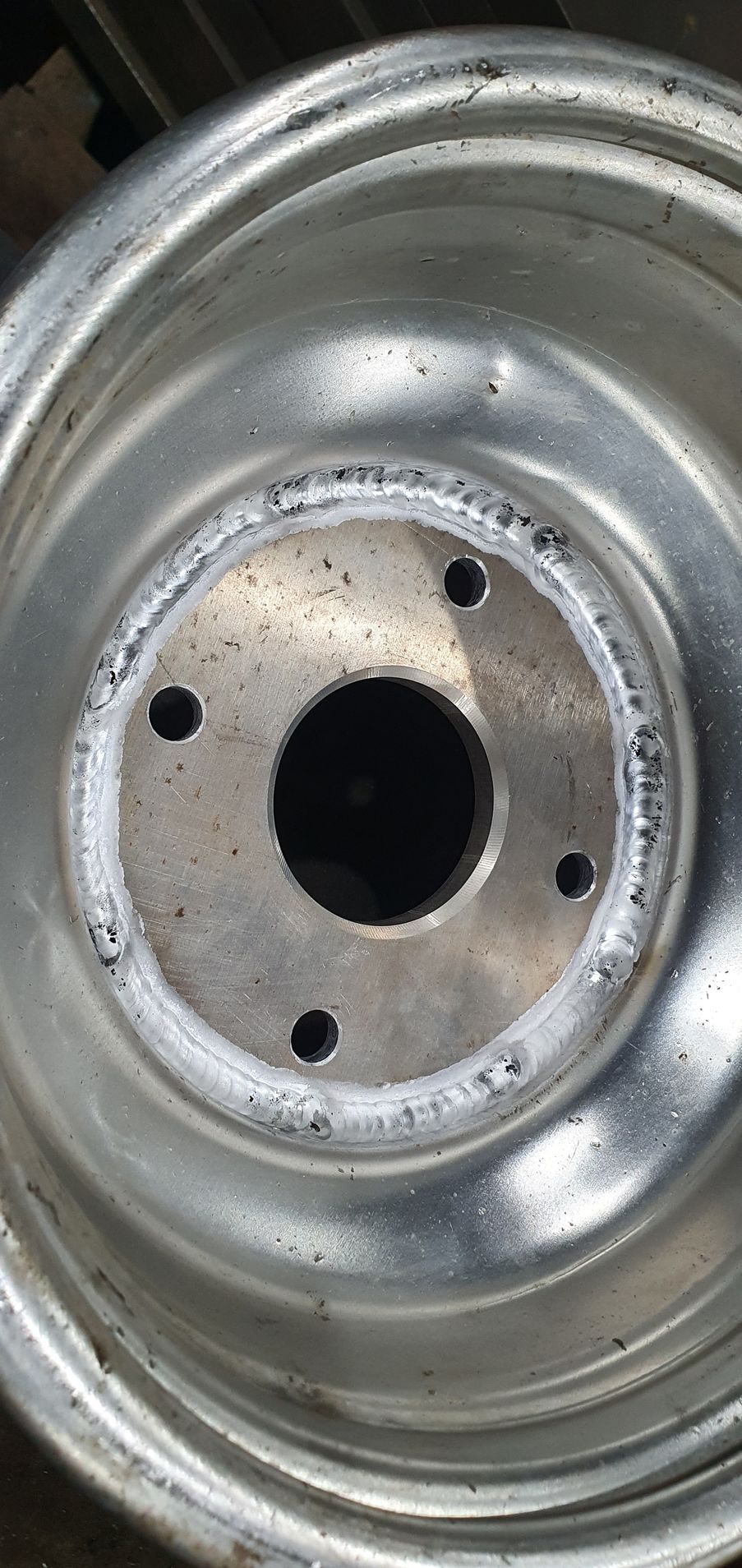A close up of a metal wheel with a hole in the middle.