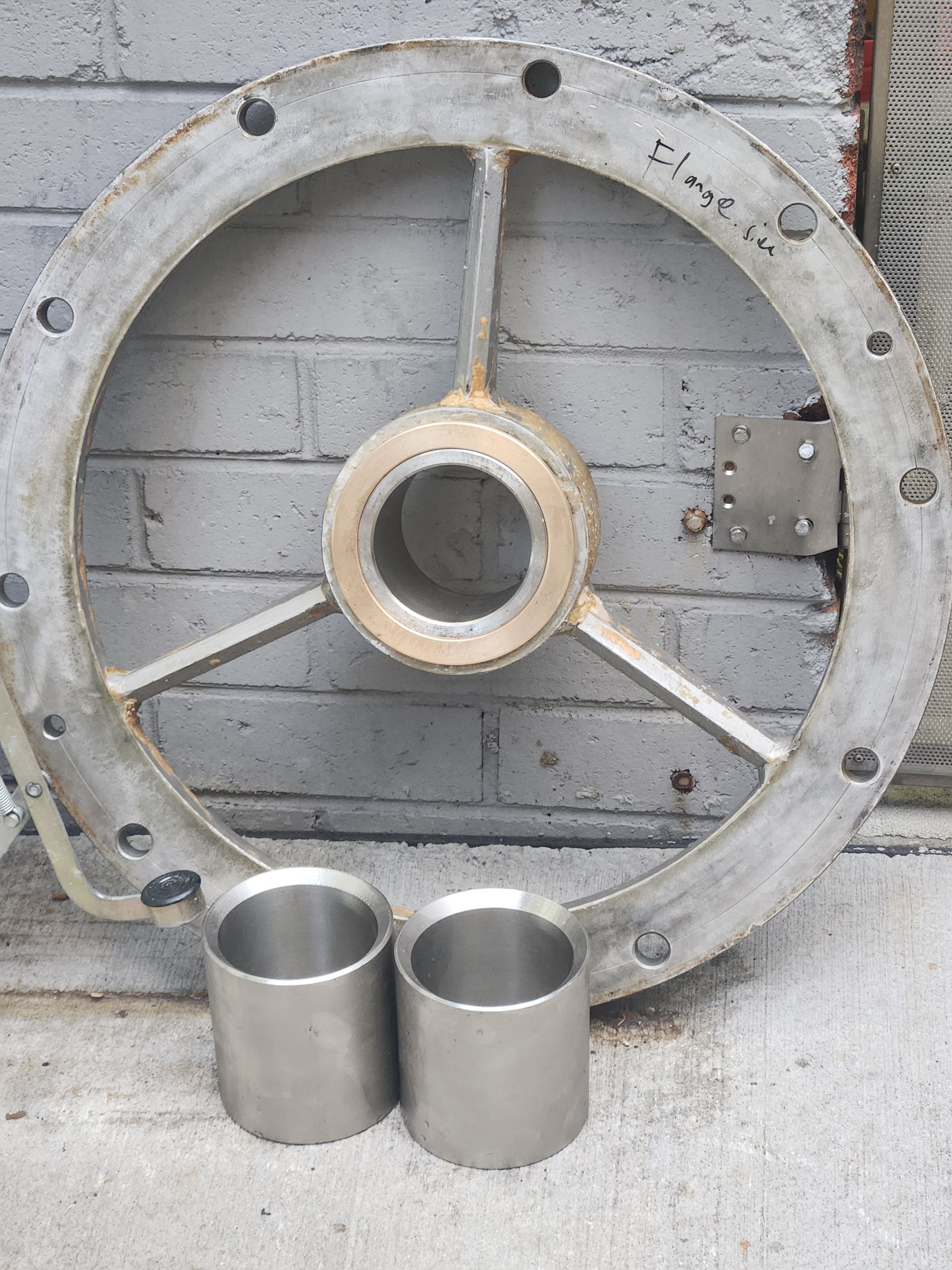 A metal wheel with two metal cups next to it