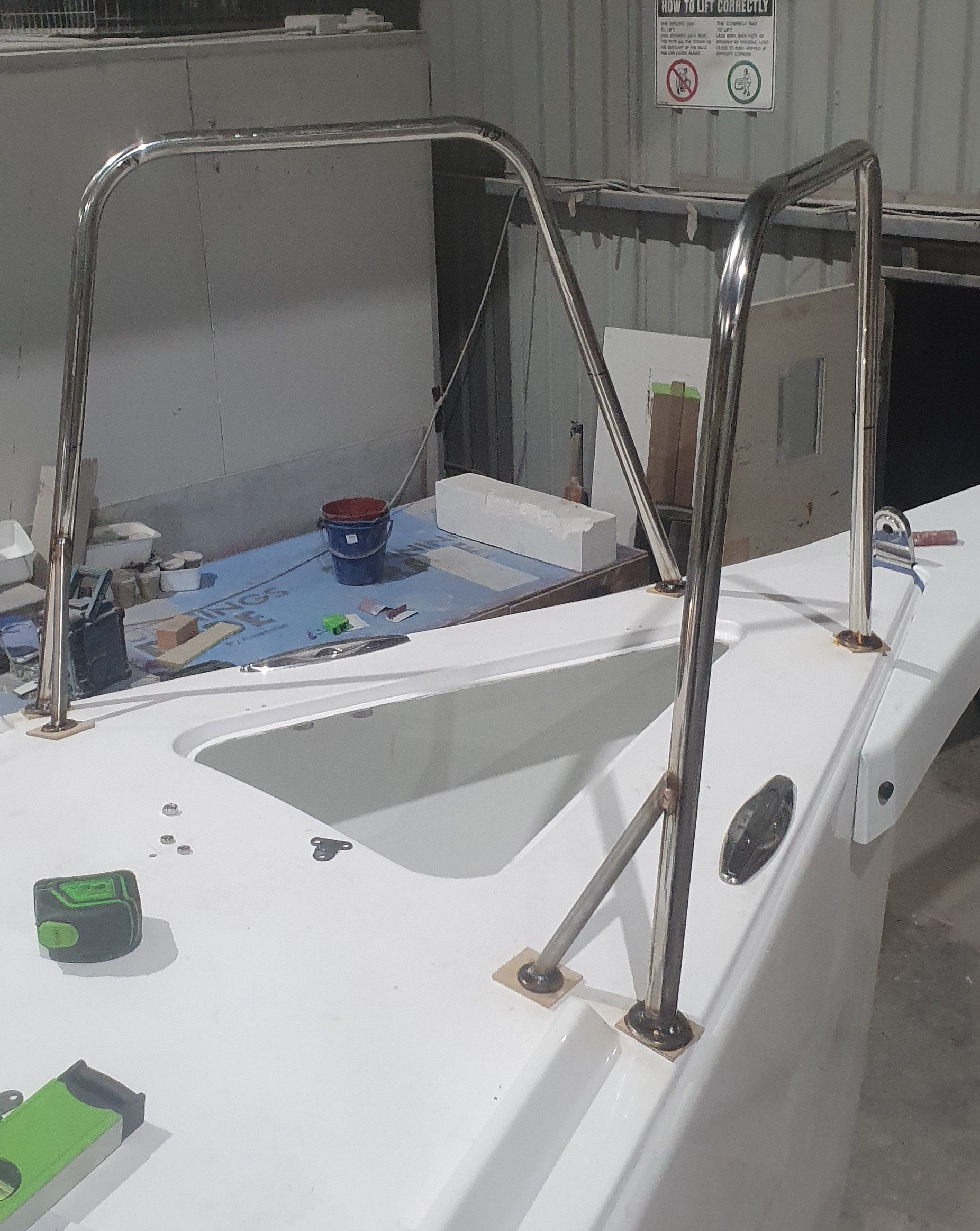 A white boat with a metal railing on top of it