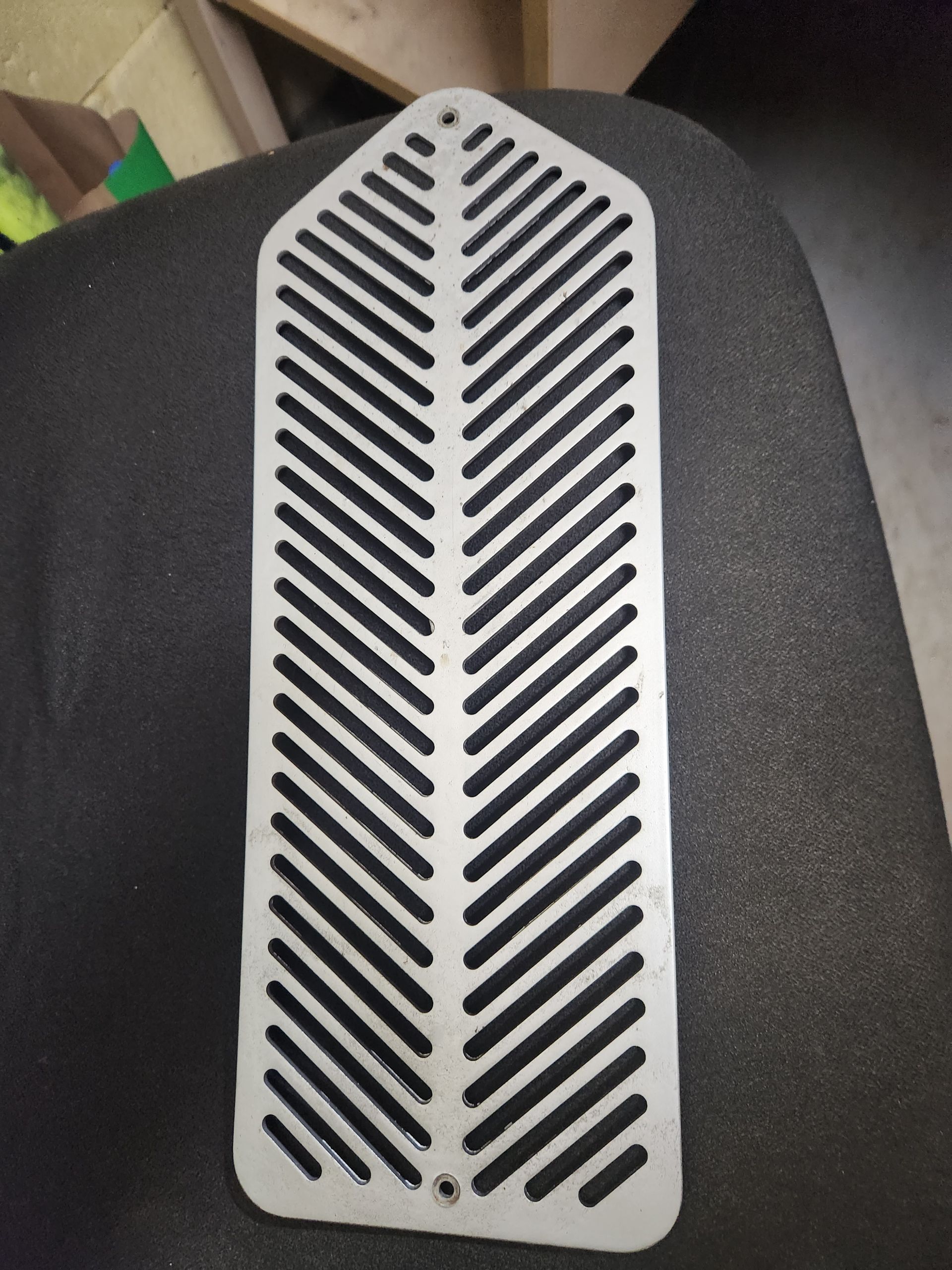A piece of metal with black stripes on it is sitting on top of a black chair.