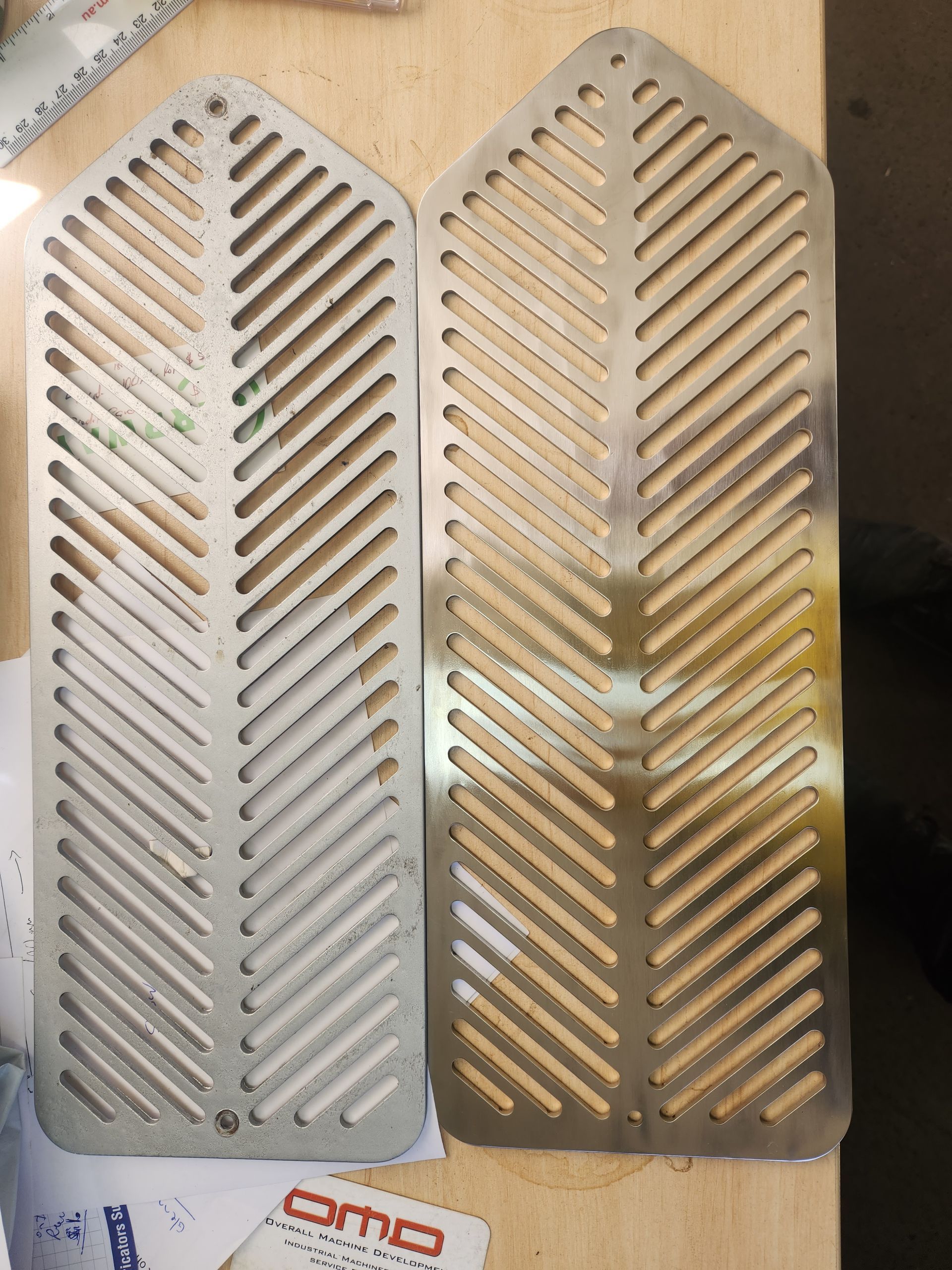 A pair of stainless steel grills are sitting on a wooden table.