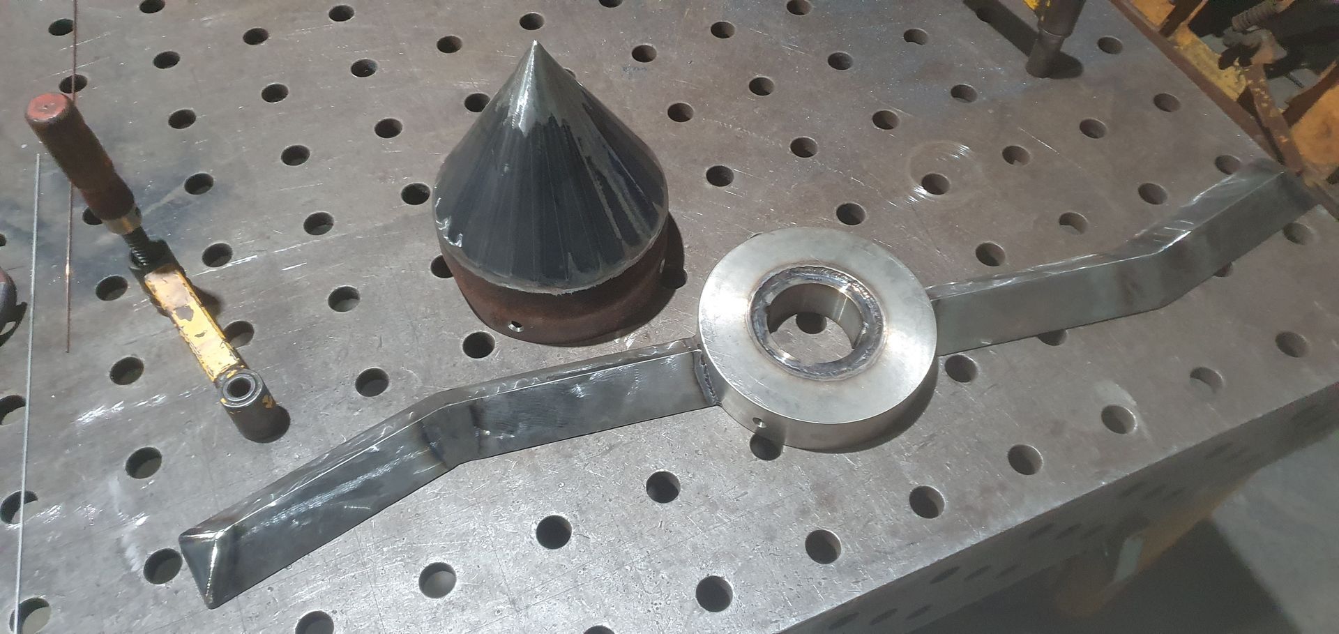 A piece of metal is sitting on top of a metal table.