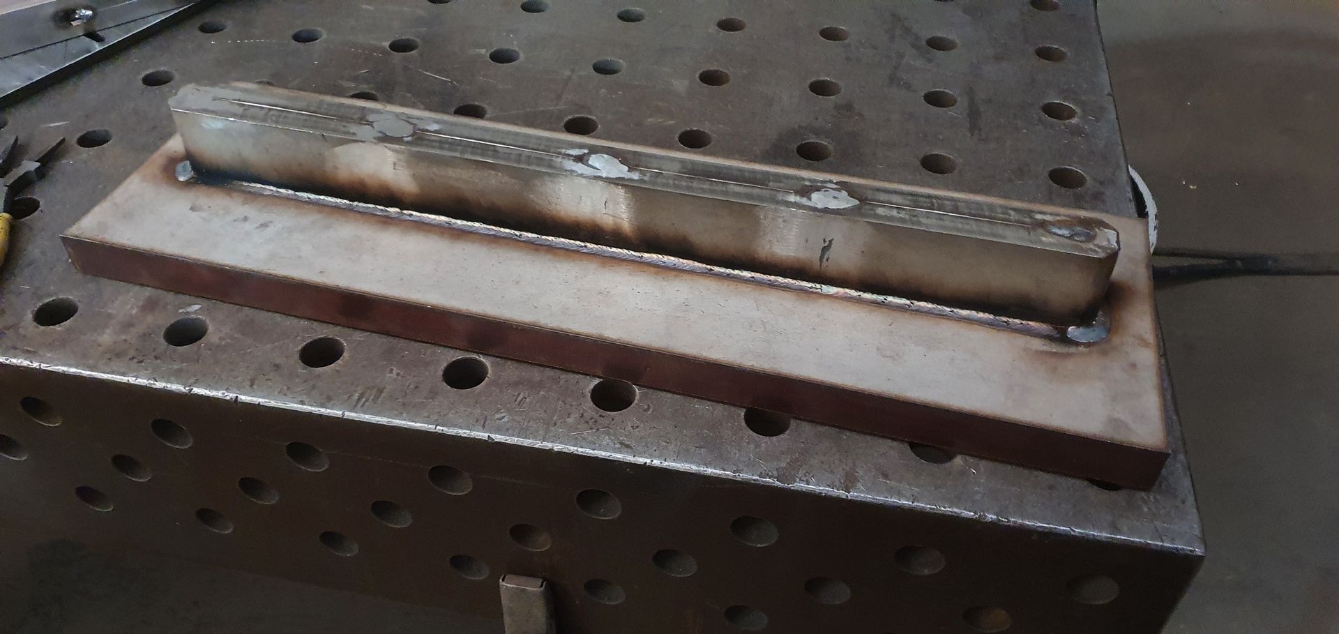 A piece of metal is sitting on top of a metal table.