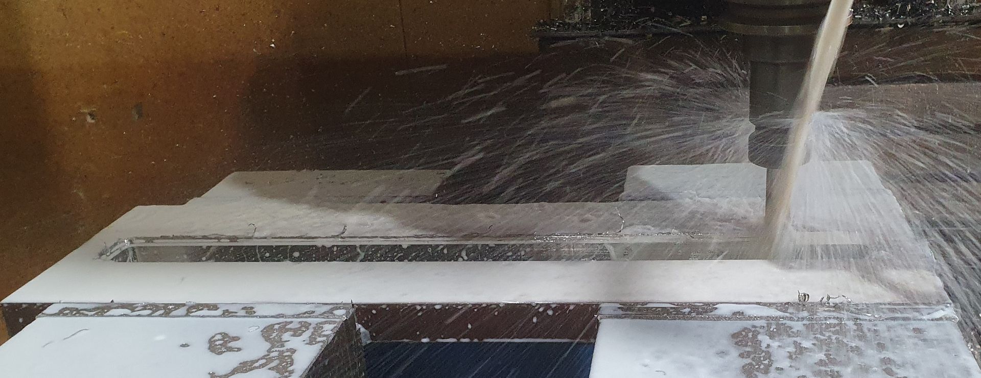 A machine is cutting a piece of plastic on a table.