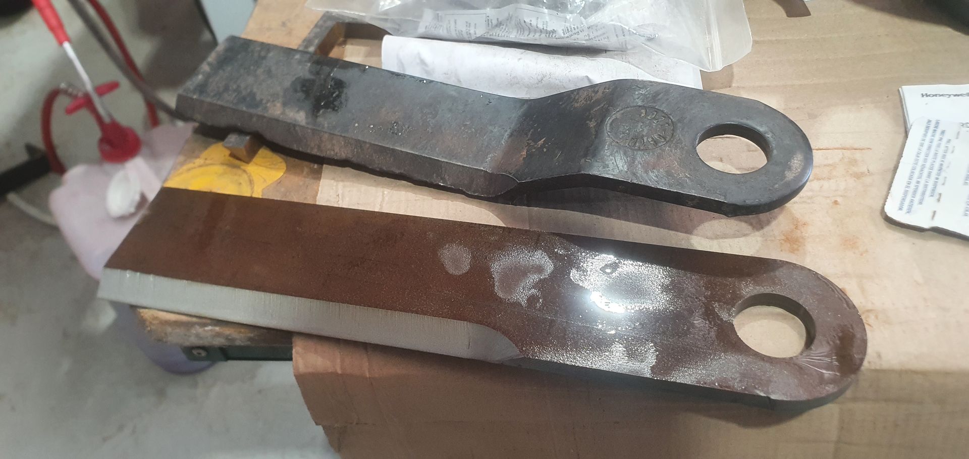 Two pieces of metal are sitting on top of a wooden table.