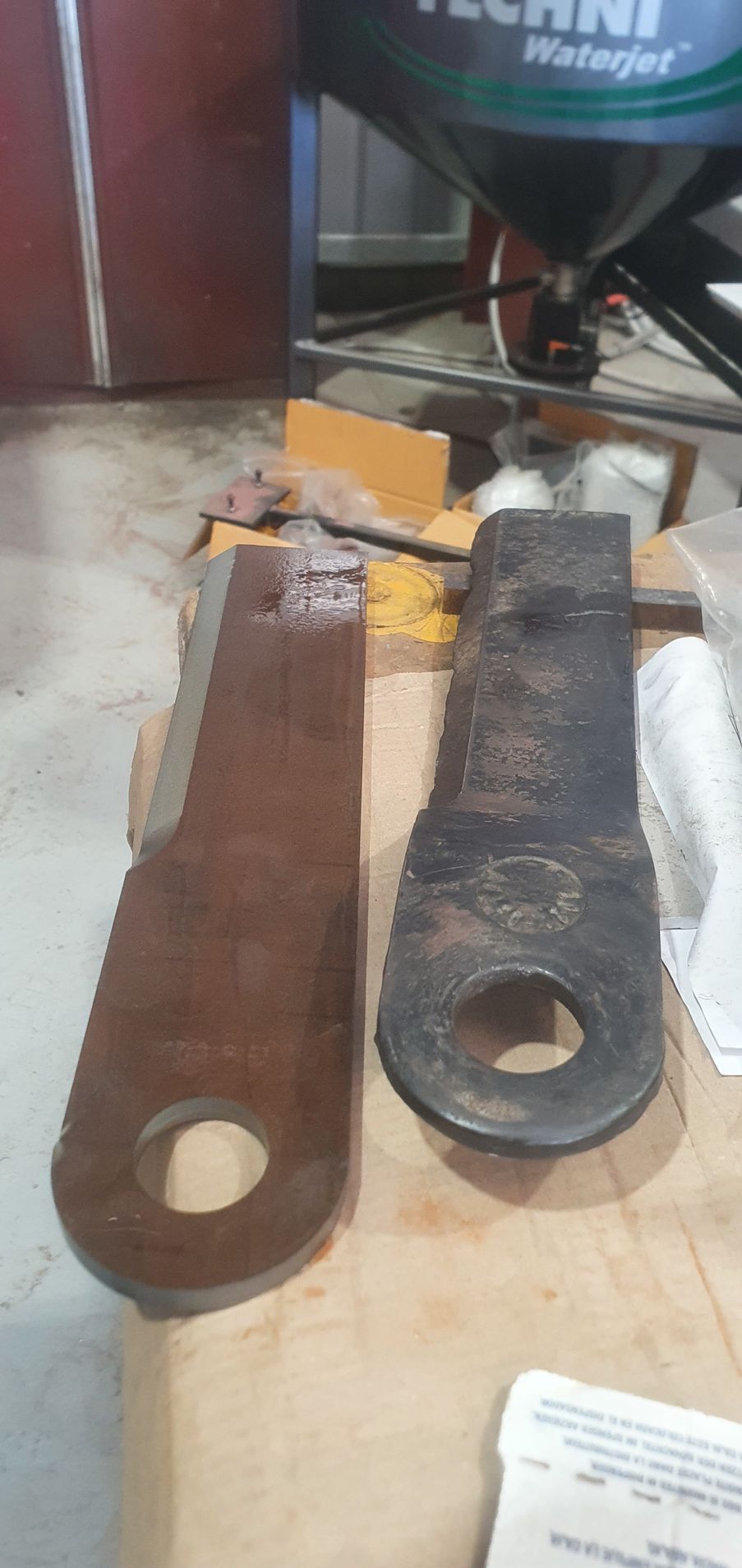 Two pieces of metal are sitting on top of a wooden table.