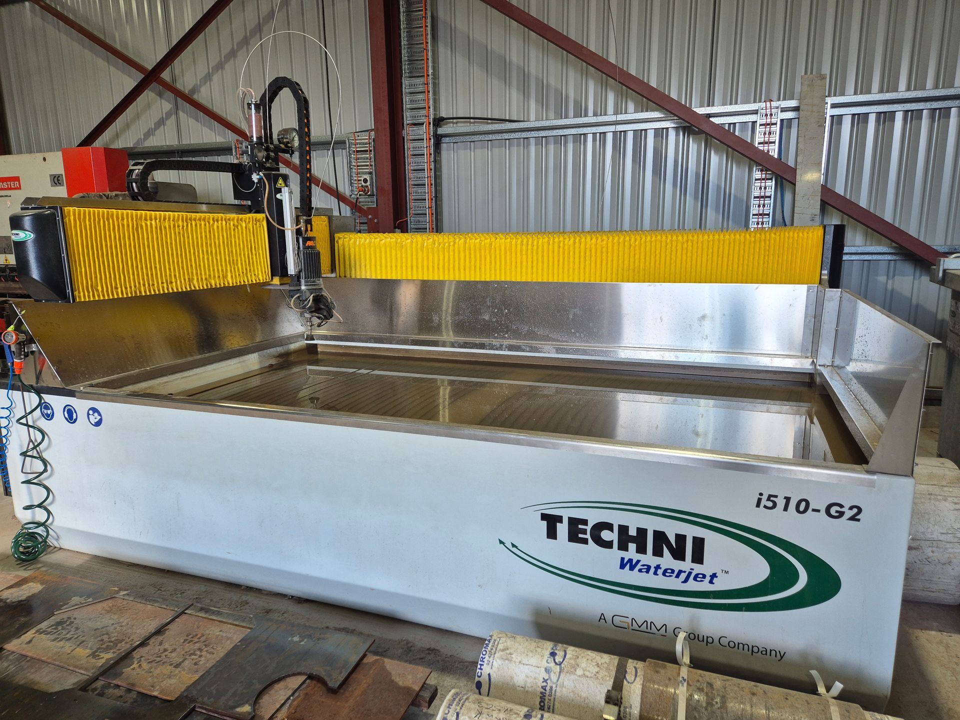 A machine is cutting a piece of metal in a warehouse.