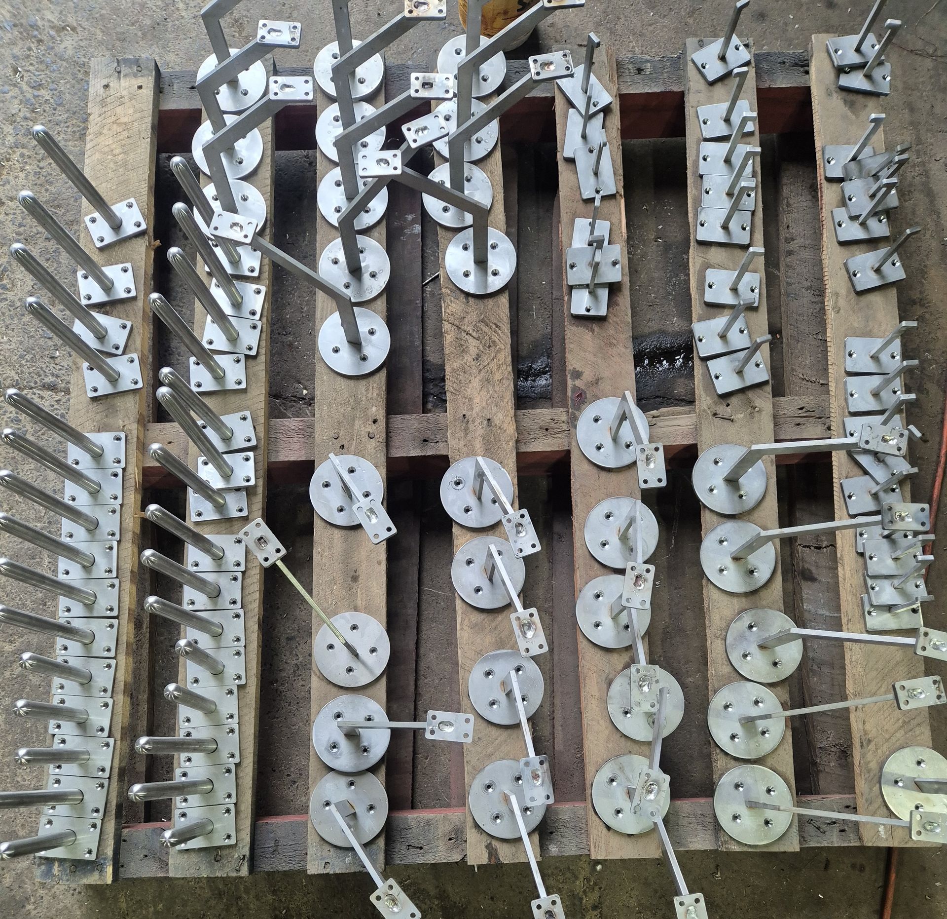 A wooden pallet with a bunch of metal hooks on it