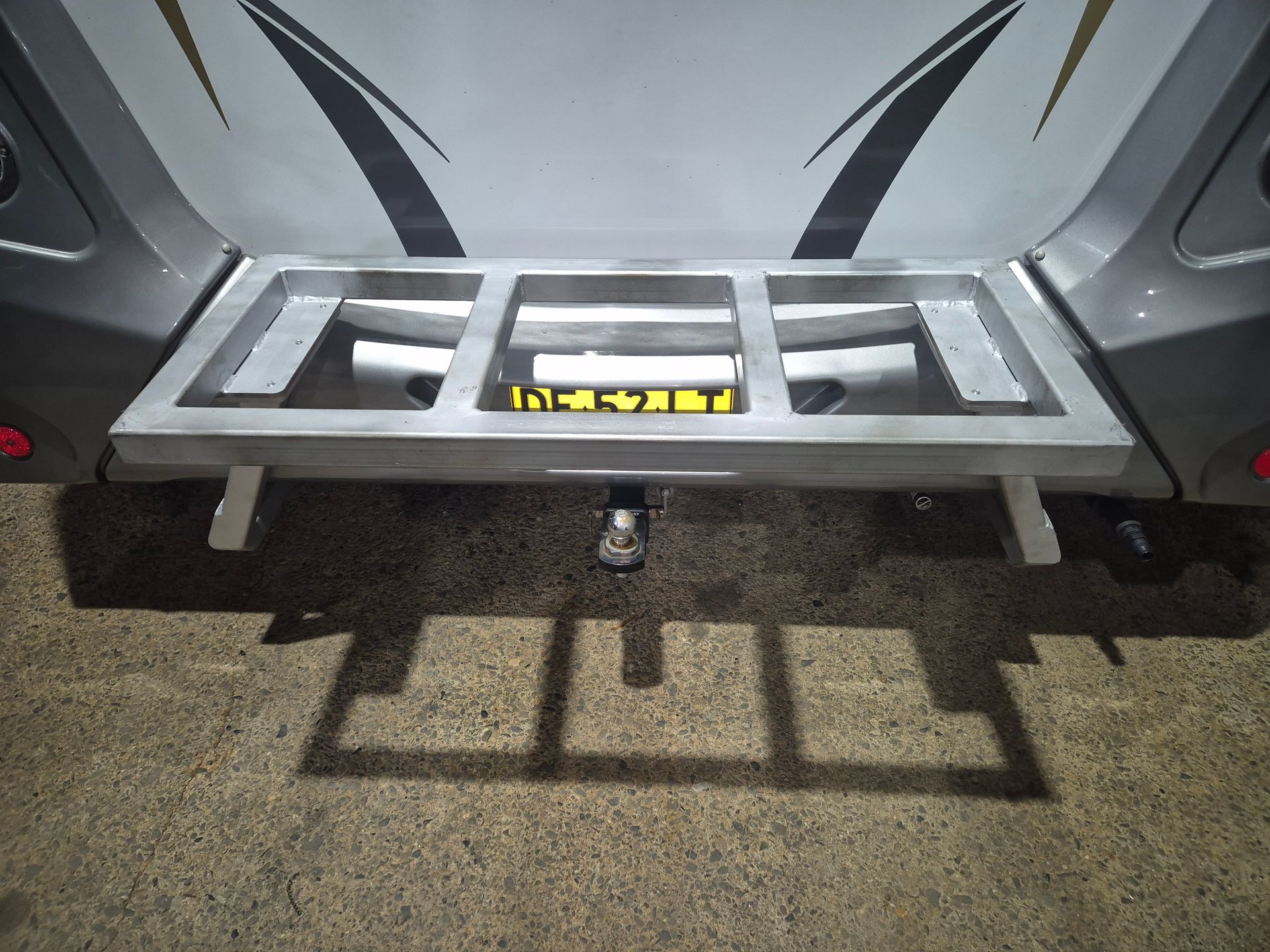 A shadow of a trailer is cast on the ground