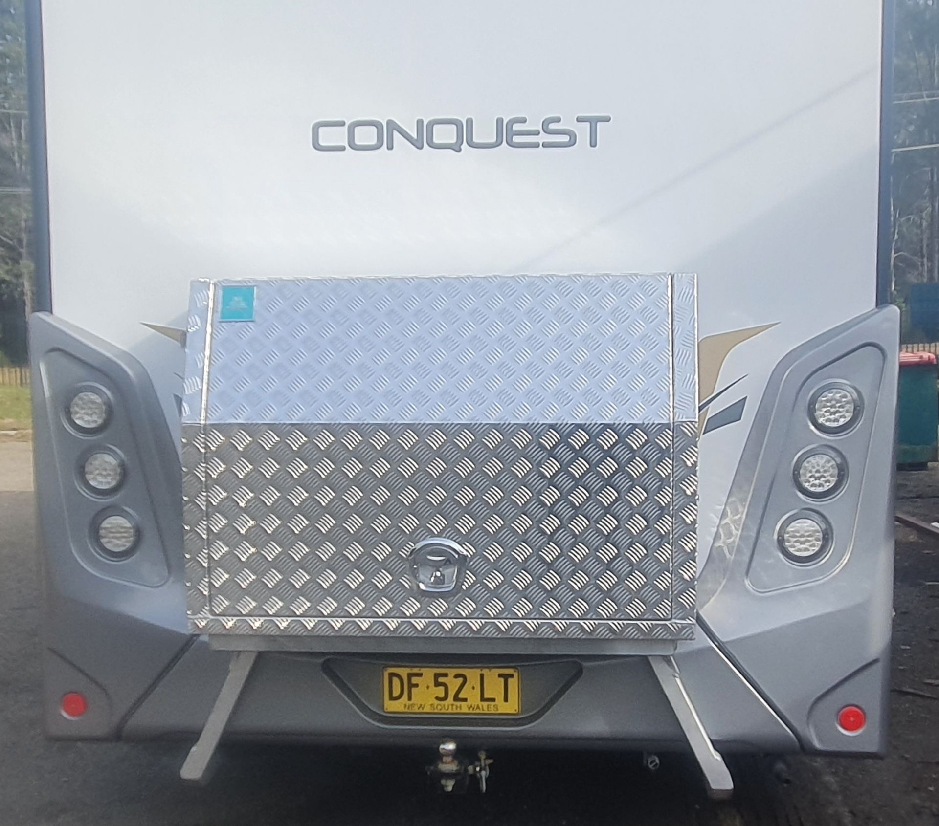 A silver rv with the word conquest on it