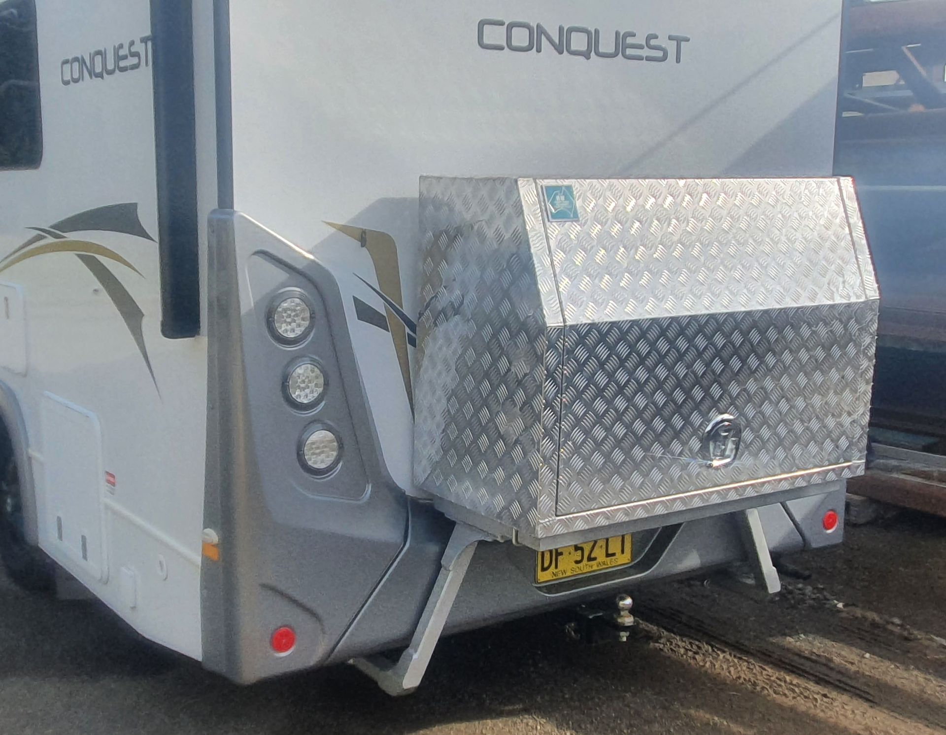 A silver rv with the word conquest on the side