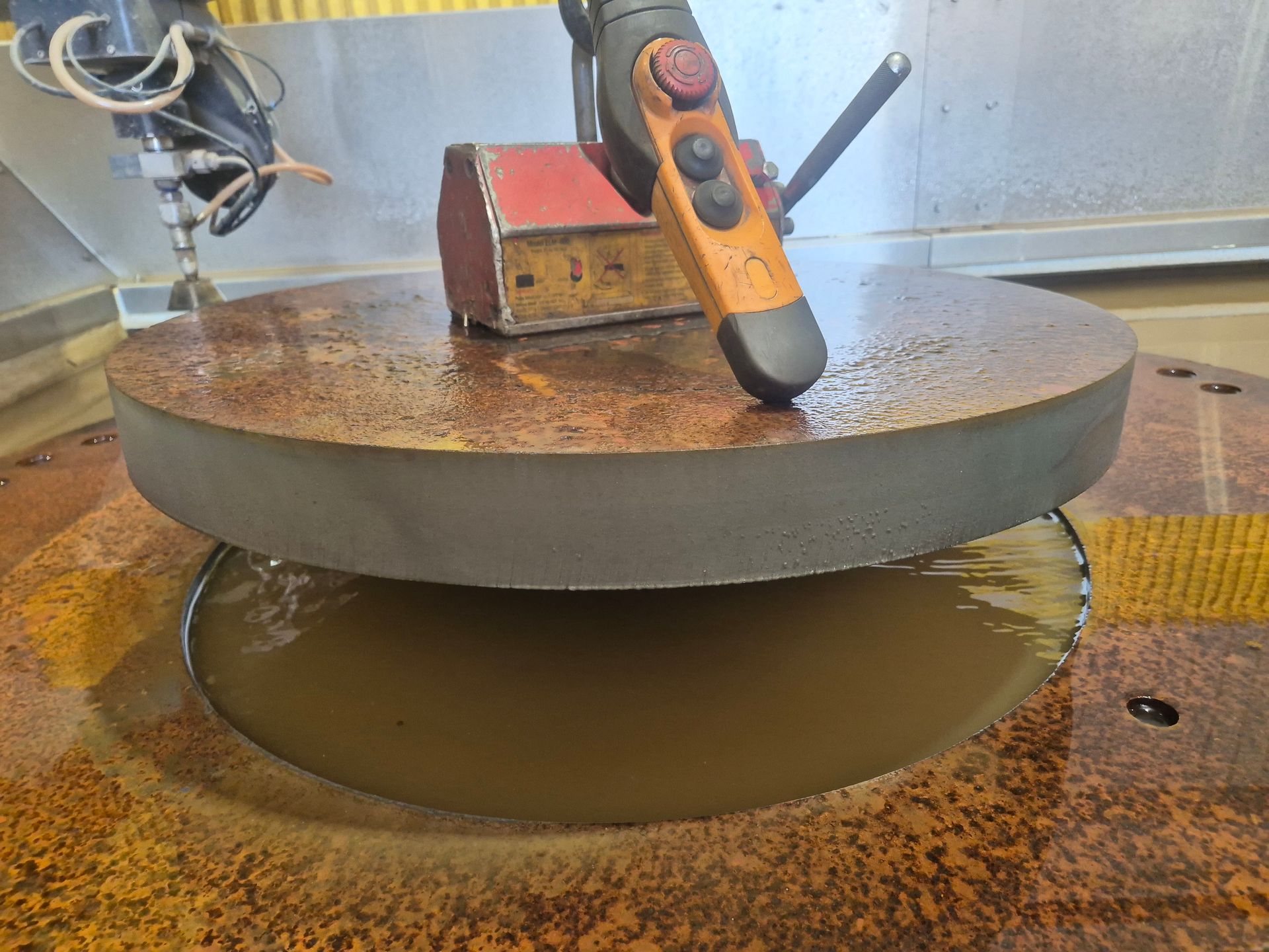 A remote control is sitting on top of a round piece of metal.