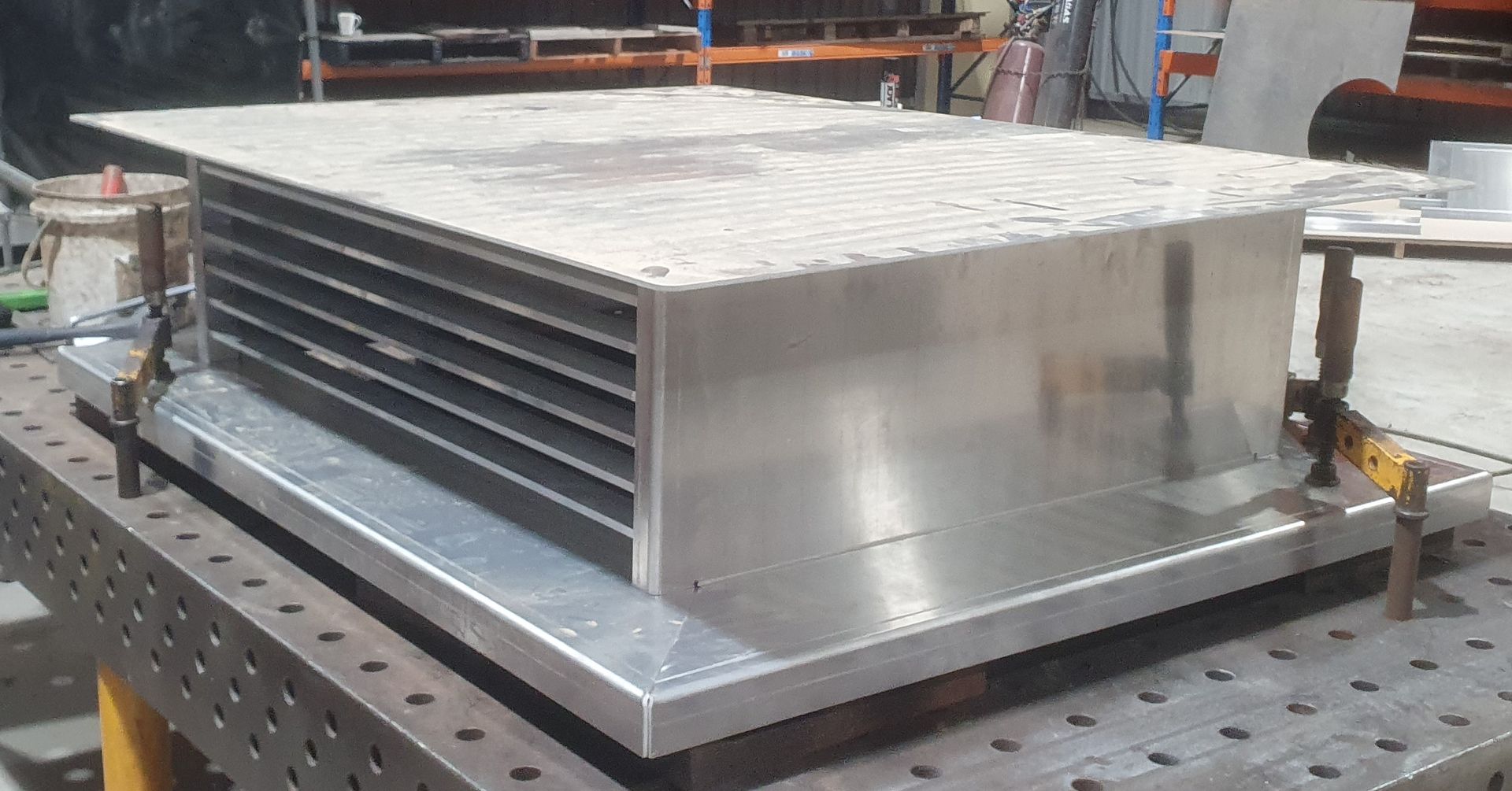 A large piece of metal is sitting on top of a metal table.