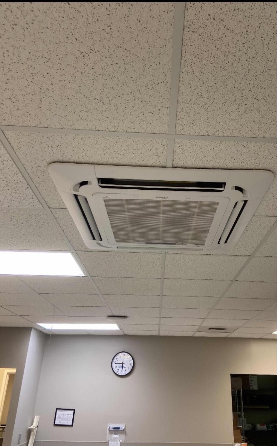 A room with a ceiling fan and a clock on the wall.