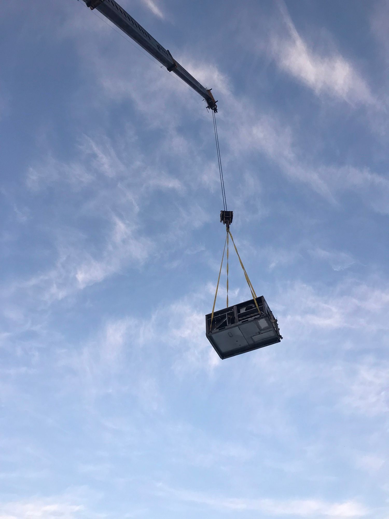 A crane is lifting a box in the air.