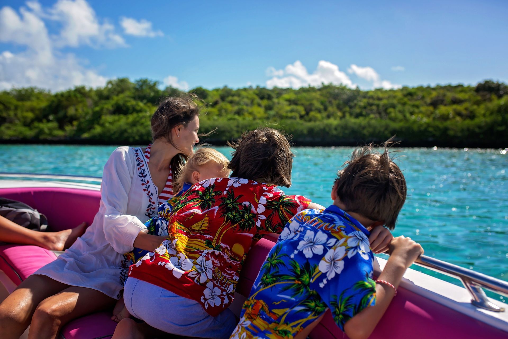 A group of people are sitting on a boat in the water. Vacation Travel Exclusives