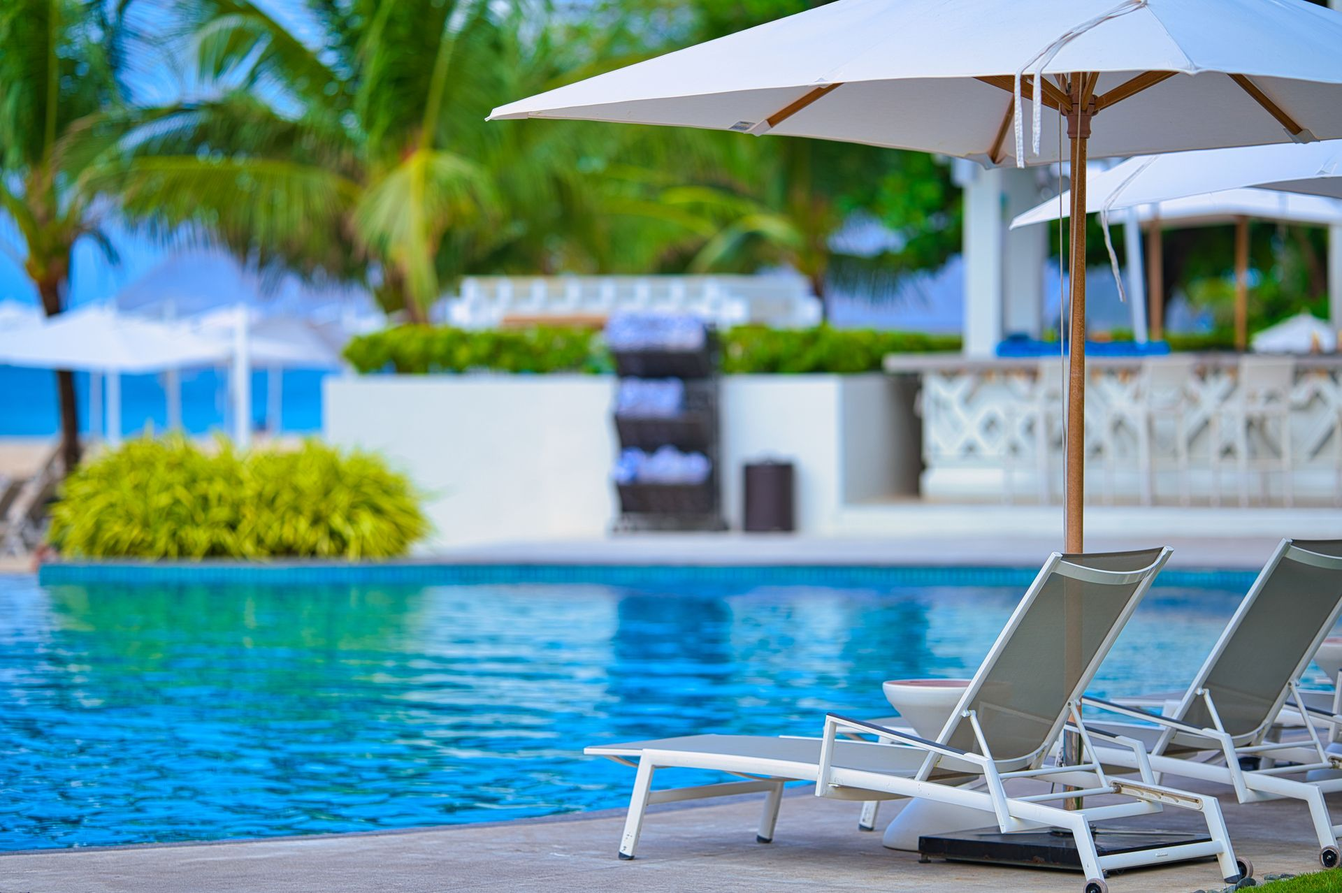 Poolside chairs and umbrellas , Vacation Travel Exclusives