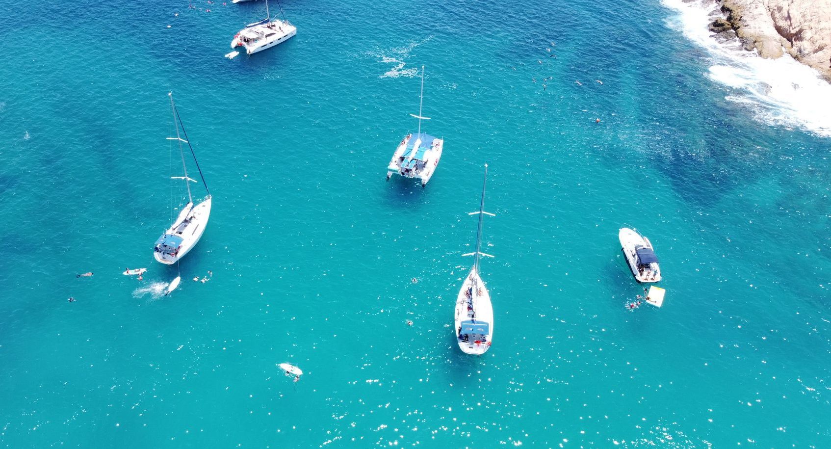 A group of boats are floating on top of a body of water.