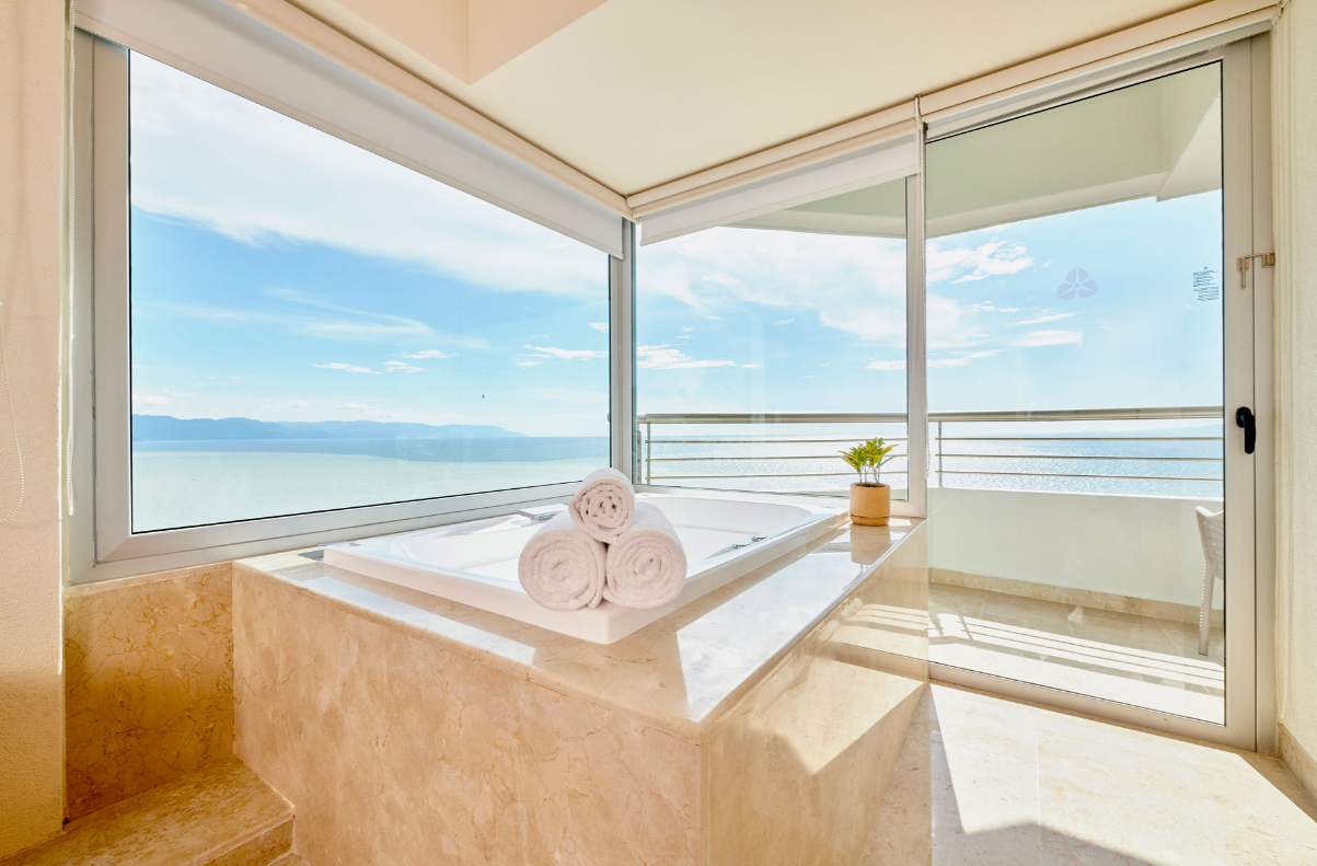A bathroom with a jacuzzi tub and a view of the ocean in Puerto Vallarta. Vacation Travel Exclusives