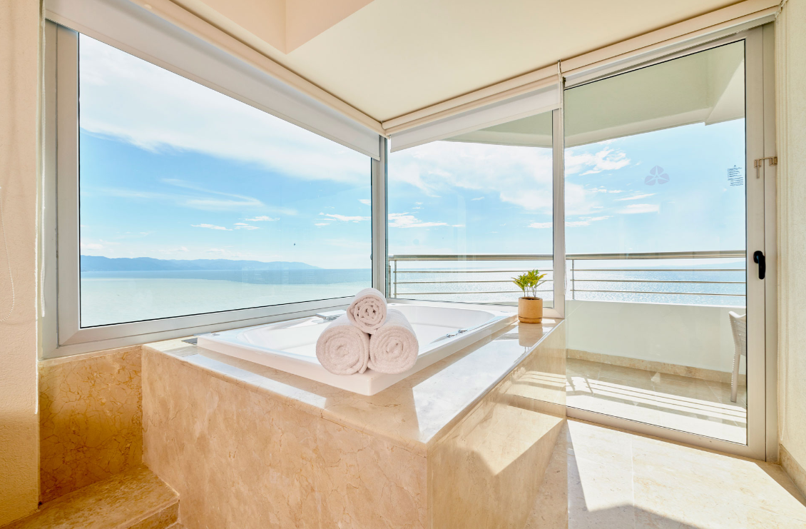 A bathroom with a jacuzzi tub and a view of the ocean