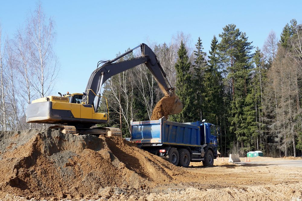 Woman in straw hat smiles, holding wine glass near a lake.