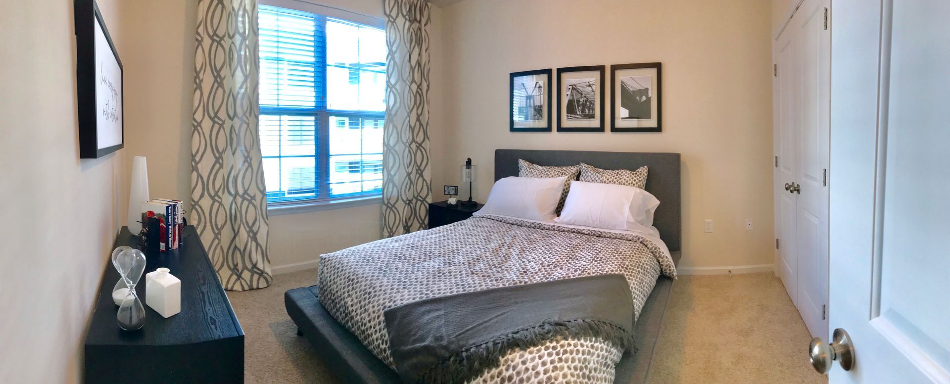 A bedroom with a bed , dresser , and window.