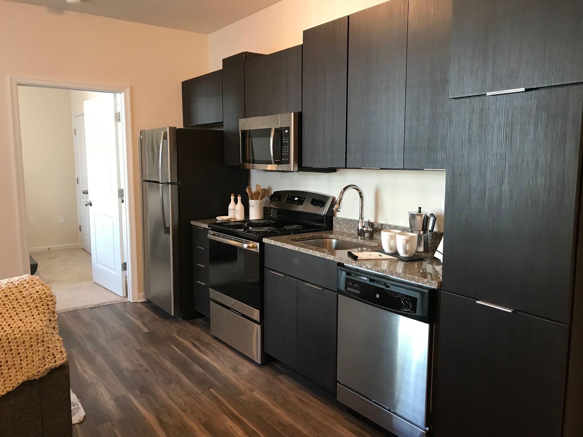 A kitchen with stainless steel appliances and black cabinets
