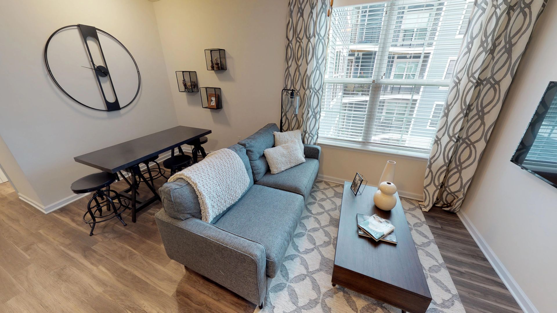 A living room with a couch , chair , table and window.