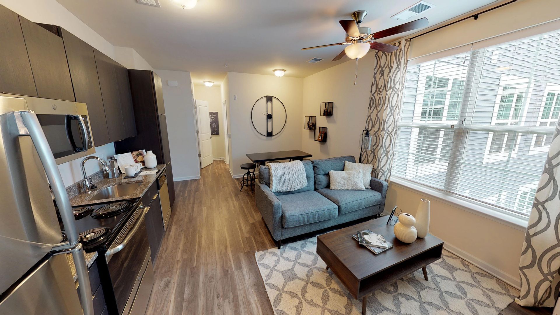 A living room with a couch , coffee table , and a ceiling fan.