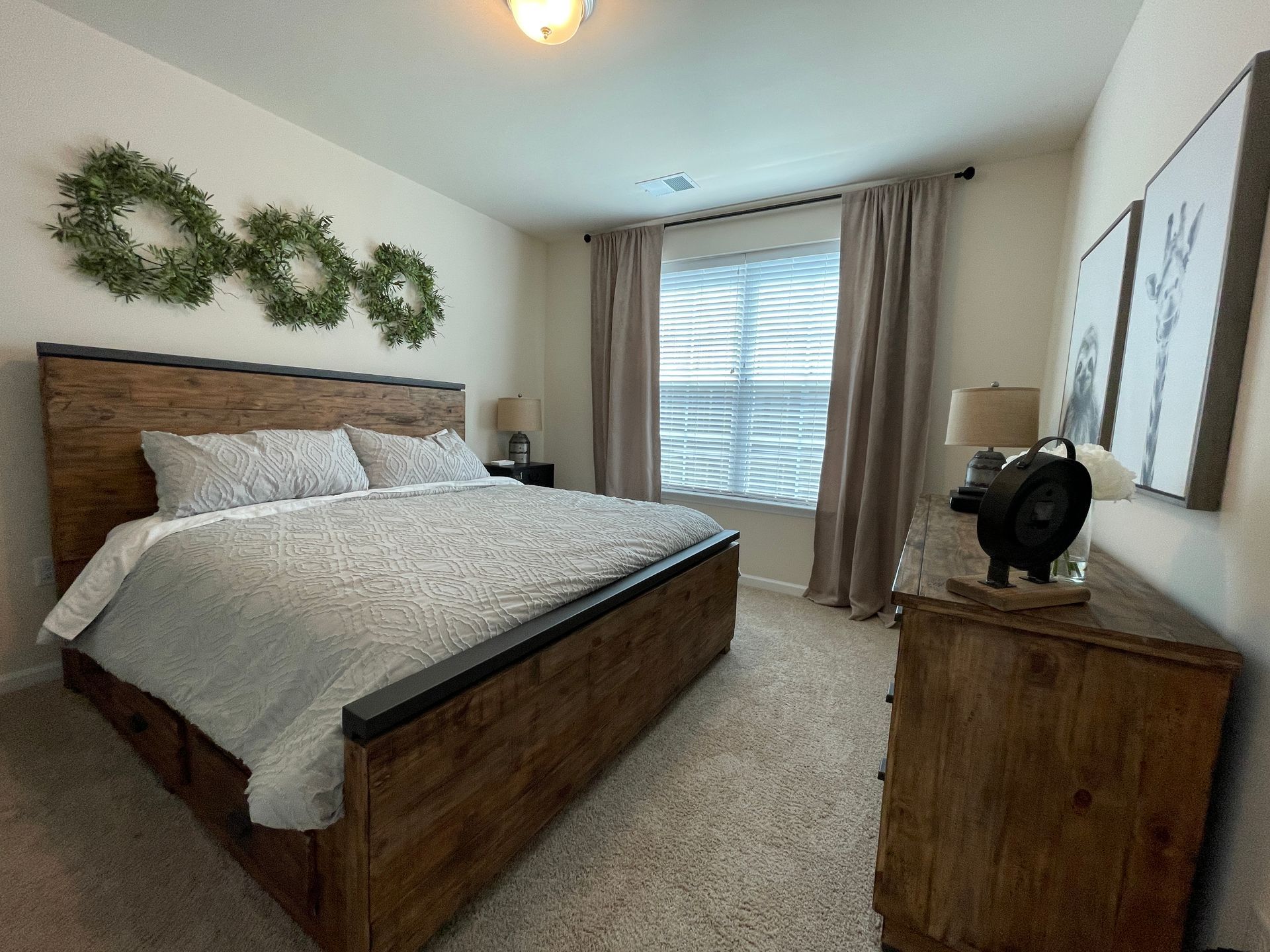 A bedroom with a king size bed and a dresser.