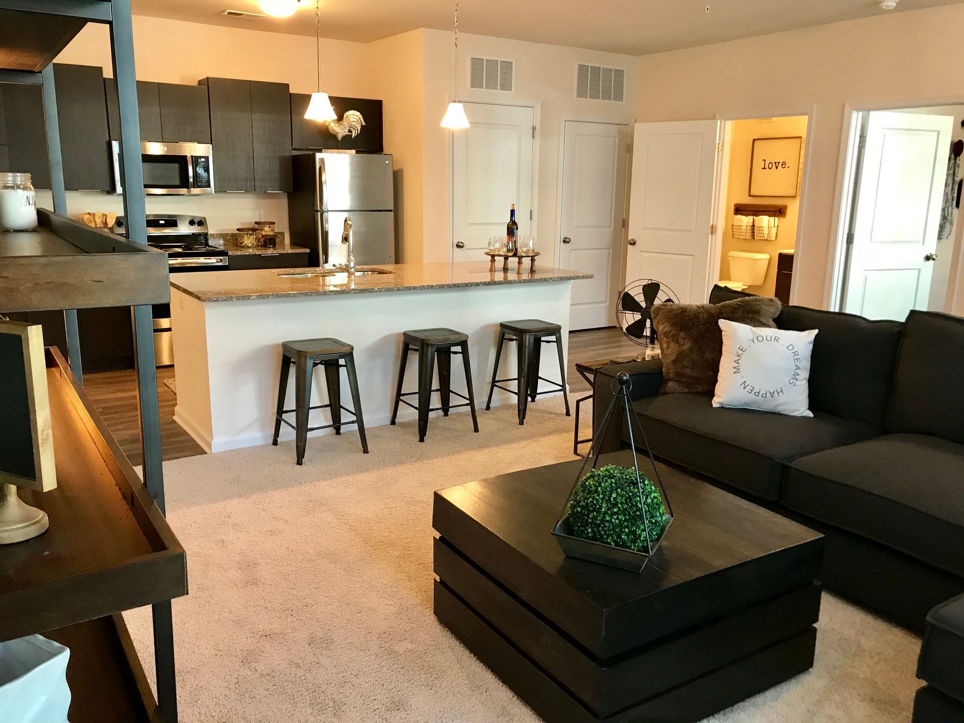 A living room with a black couch and a black coffee table
