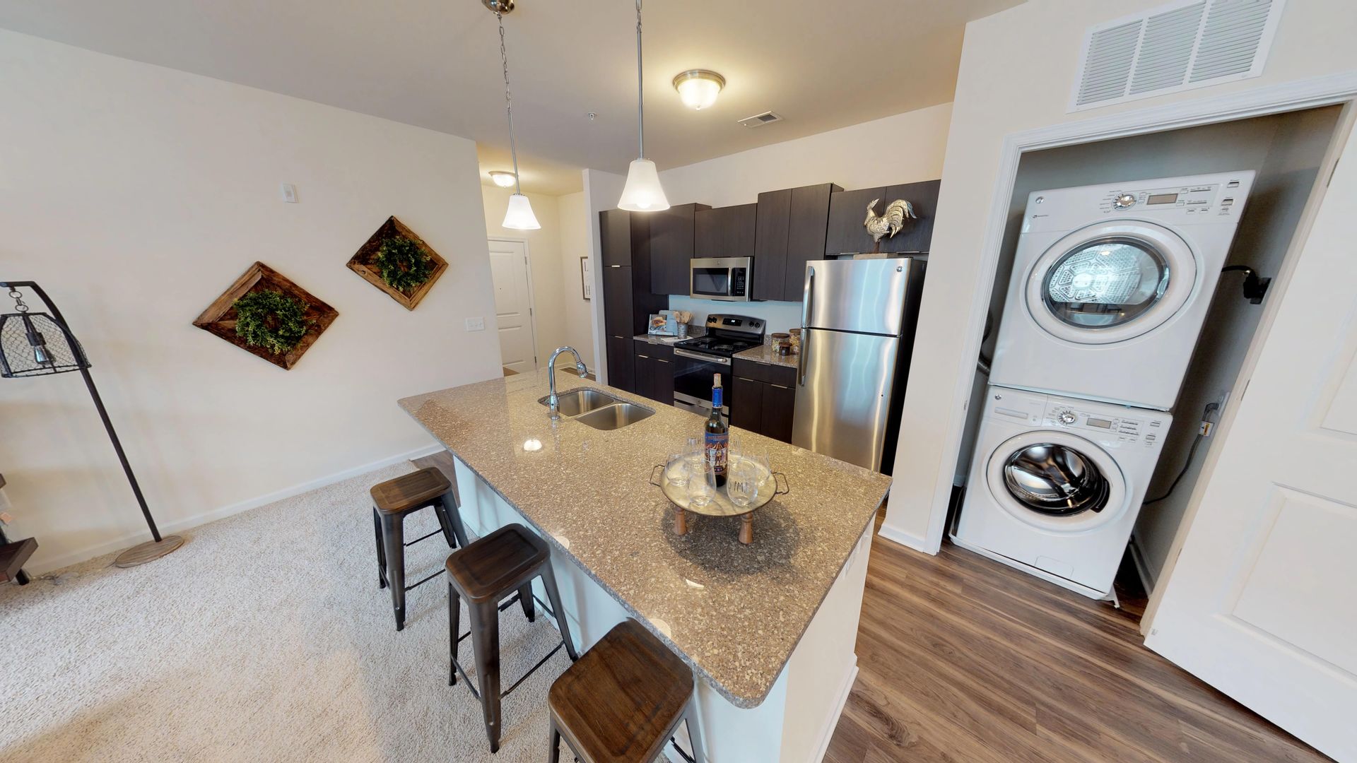 A kitchen with a washer and dryer stacked on top of each other.