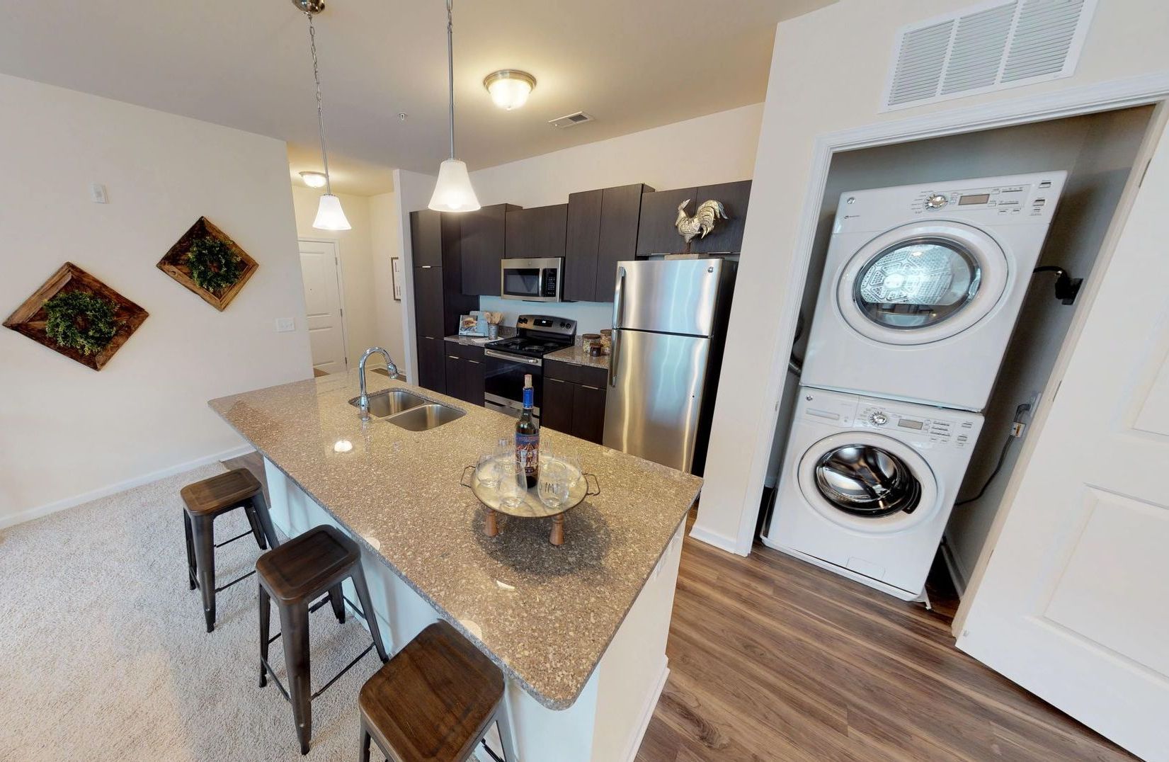 A kitchen with a washer and dryer stacked on top of each other.