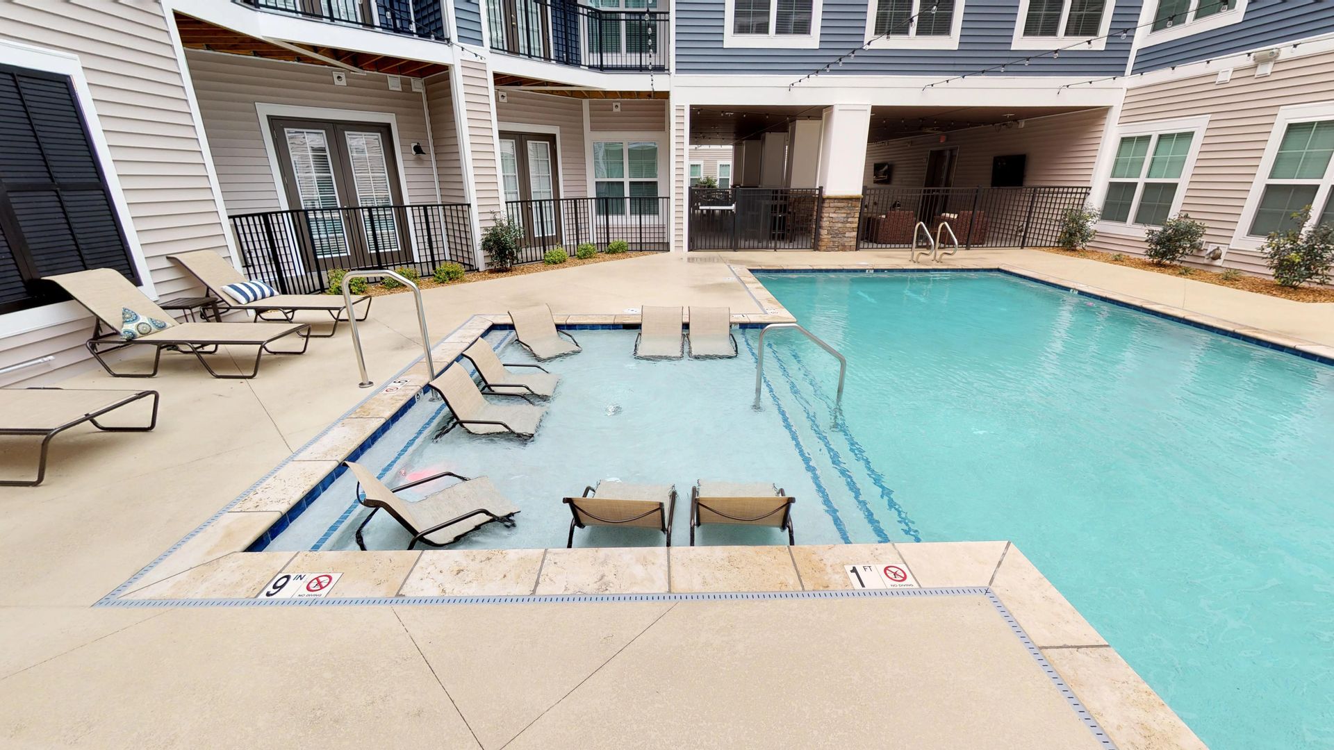 There is a large swimming pool in the middle of a building.